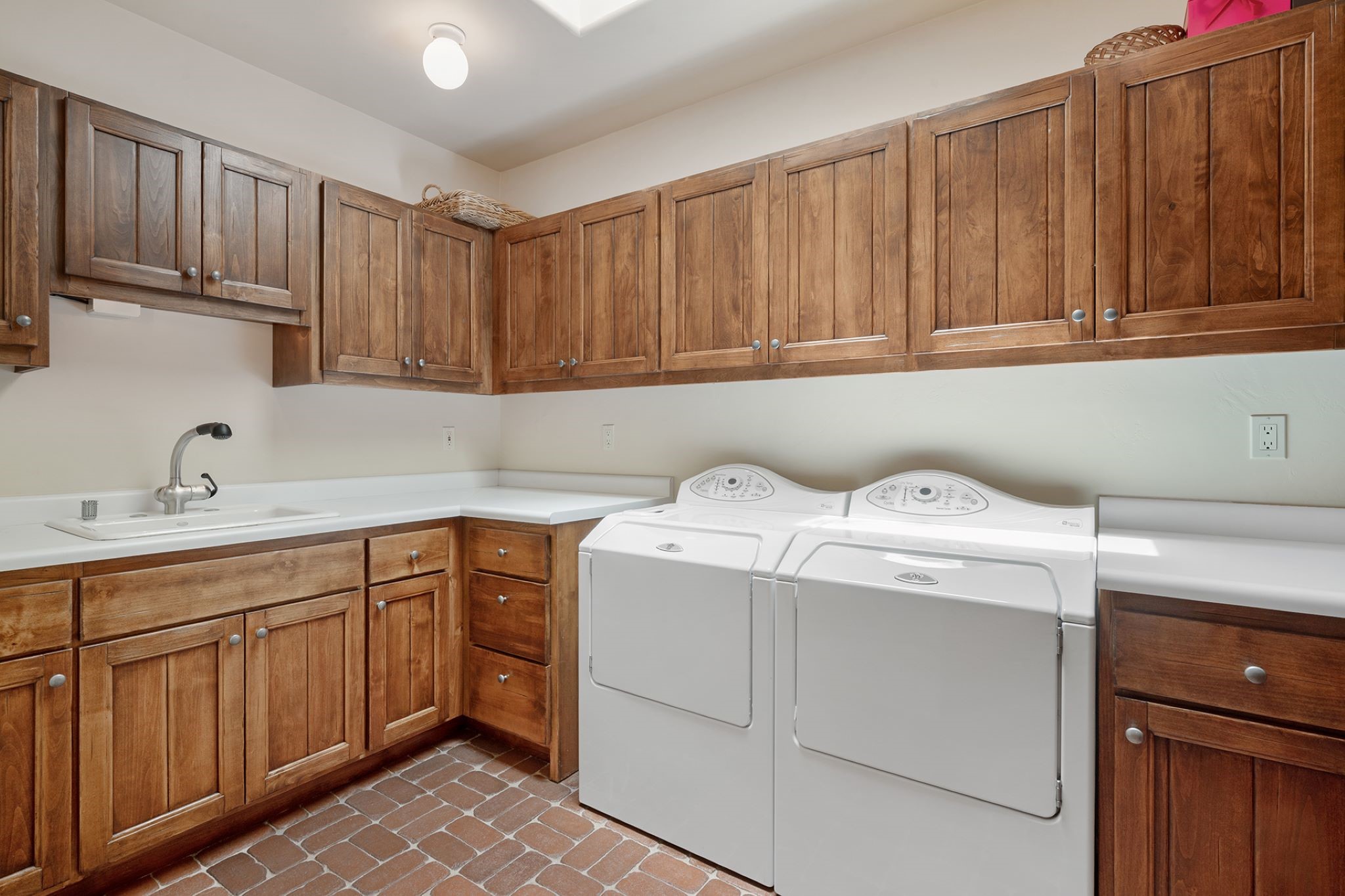 Laundry room sink with upper and lower cabinets.