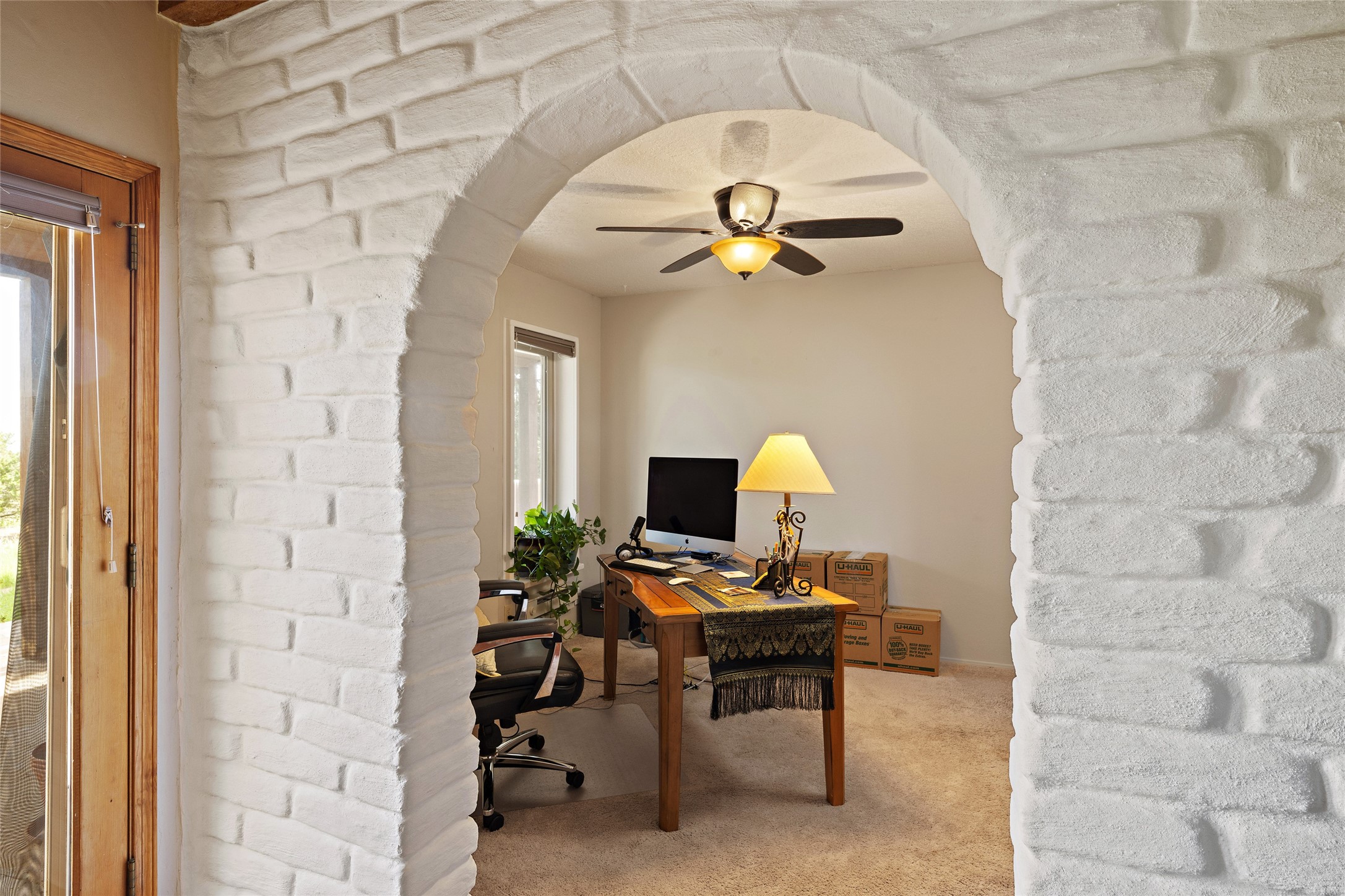 Arched Trombe wall leading into office