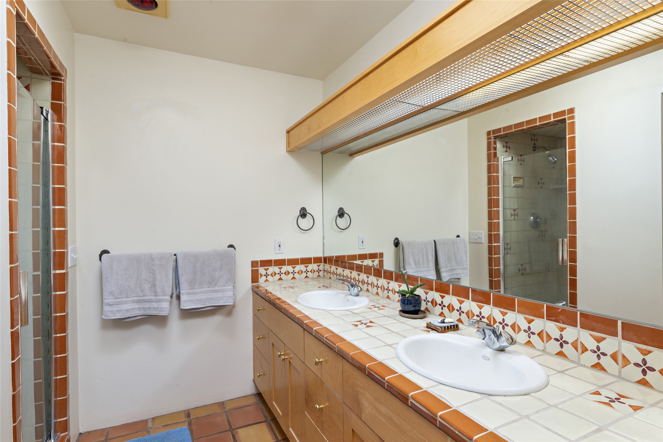 Double sinks in the primary bathroom and on the left is the walk in shower