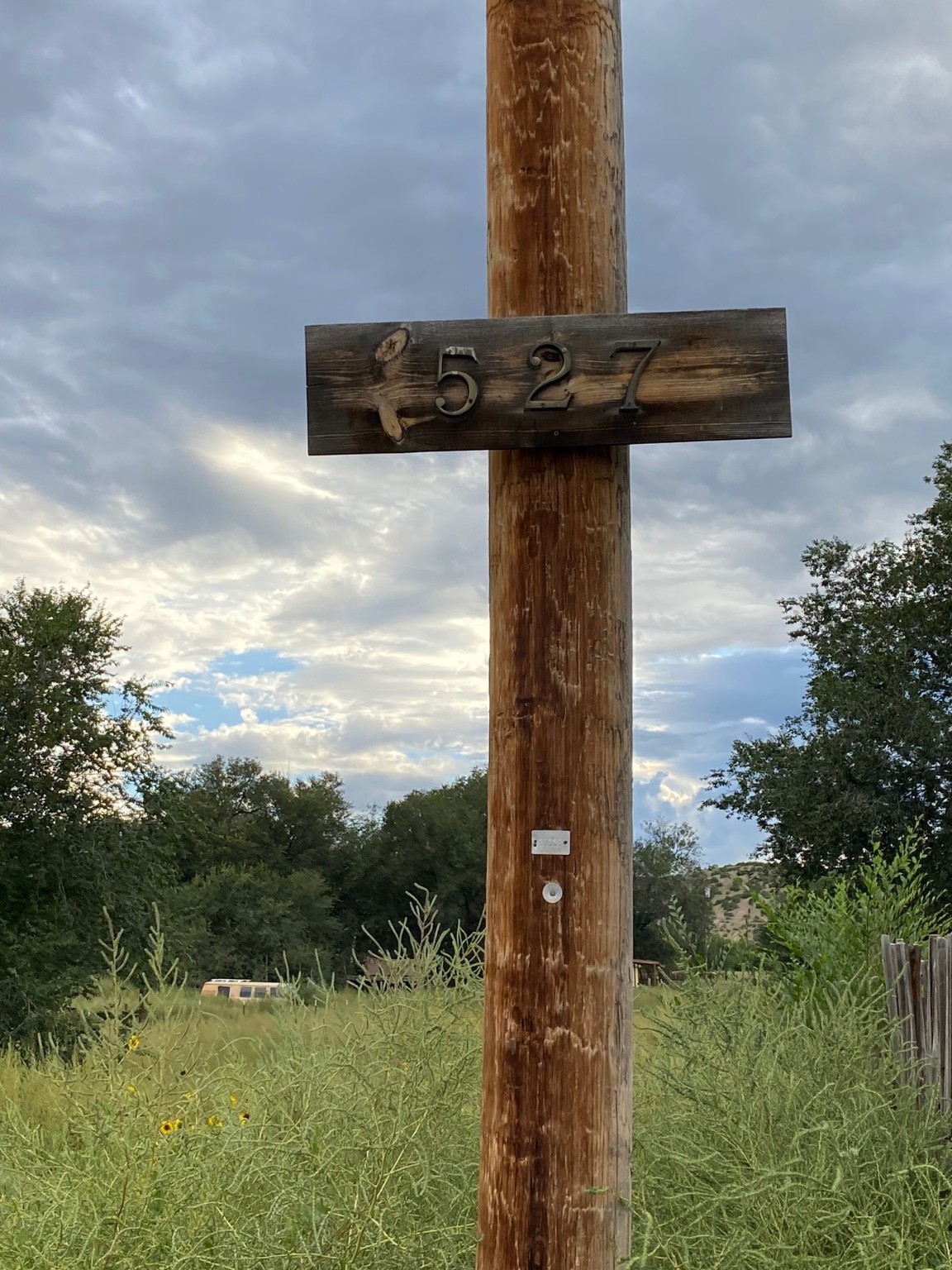 This is a old power pole that has an address sign on it. This property does not have an address yet, since it is vacant land.