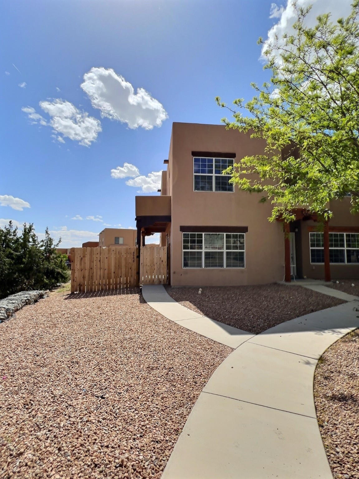 Lovely two-story townhome minutes from 599 bypass. Location 5 minutes from the Santa Fe Airport and 10 minutes via 599 to downtown Santa Fe. Home sits on a corner lot and backs to an open arroyo.  With a great view of the Sandias, this house features four bedrooms, one down and three up, two bathrooms, one down and one up. Home also offers a sweet fenced front courtyard with blackberry and strawberry bushes planted with love by the owner. Home has brand new carpet and is sold "as is."