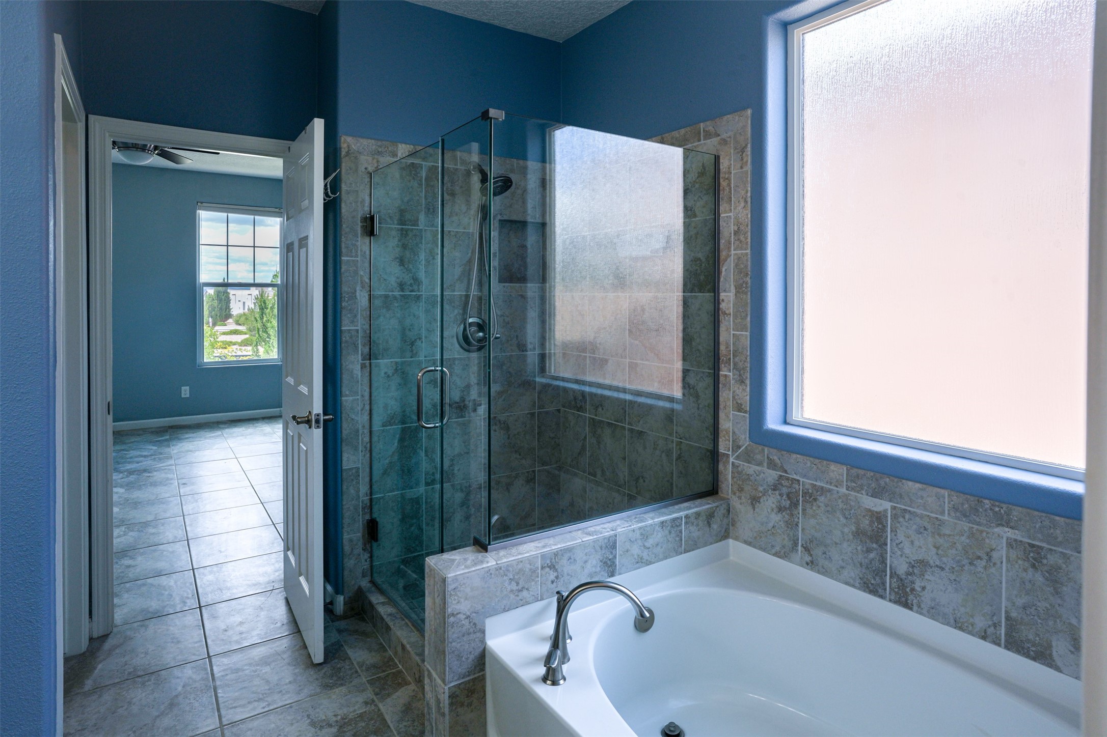 PRIMARY BATHROOM WITH ENCLOSED SHOWER AREA AND BATHTUB