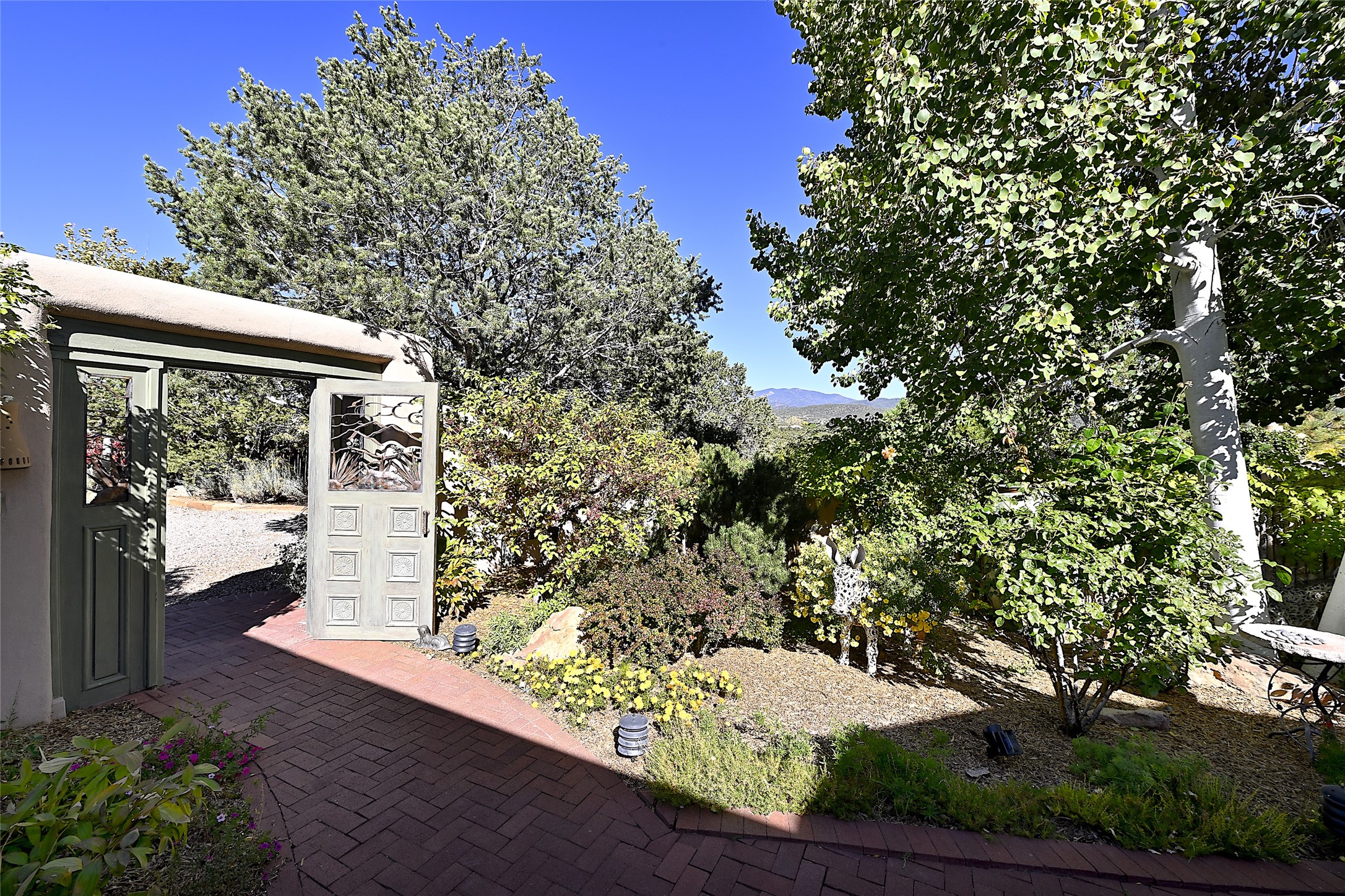 This property occupies an enviable hillside spot strewn with mature native trees and foliage. Its multiple courtyards have been colorfully landscaped;