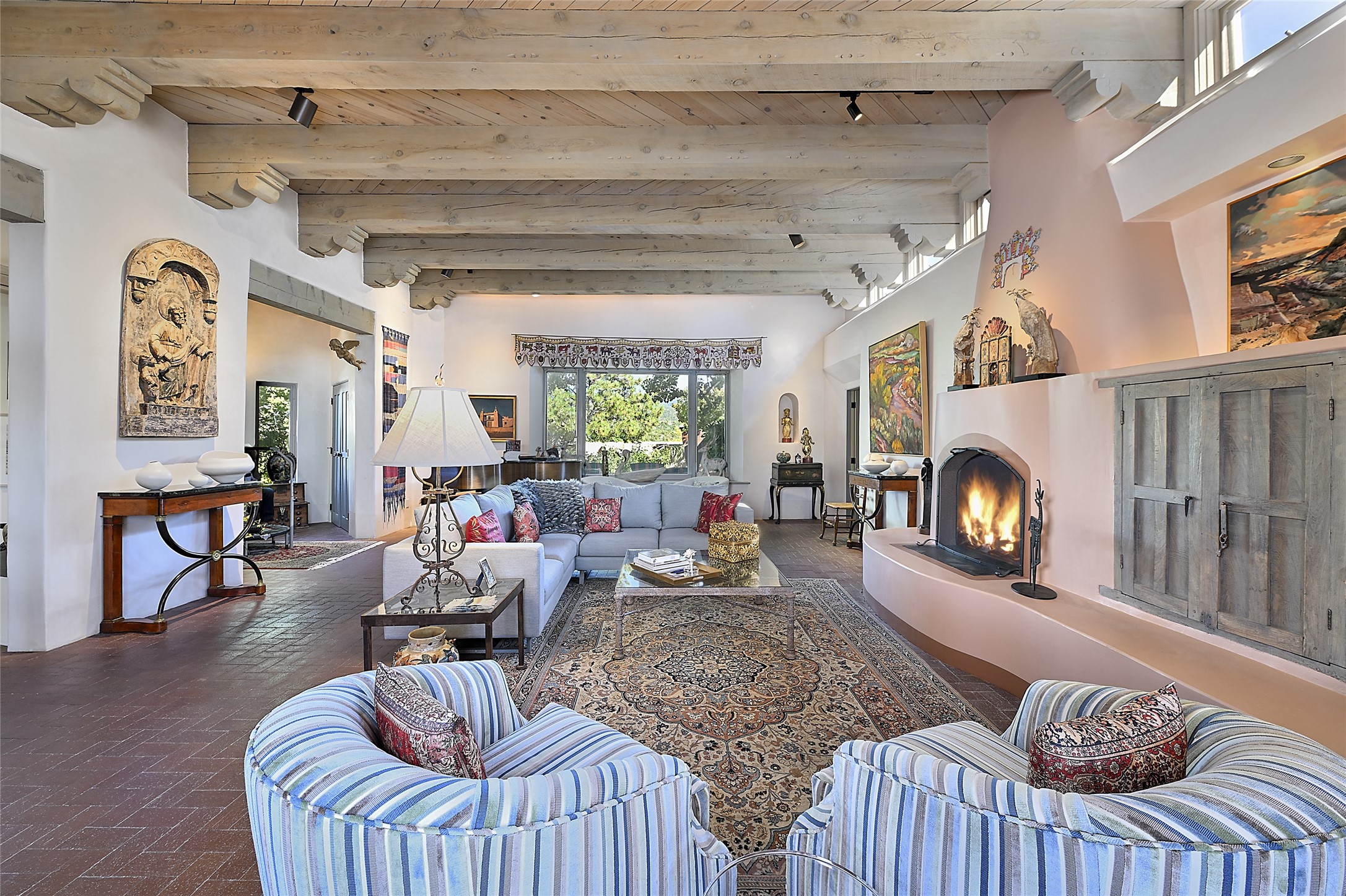 Exuding classical Santa Fe style, this magnificent living space has soaring ceilings with beams, corbels, and clerestories;
