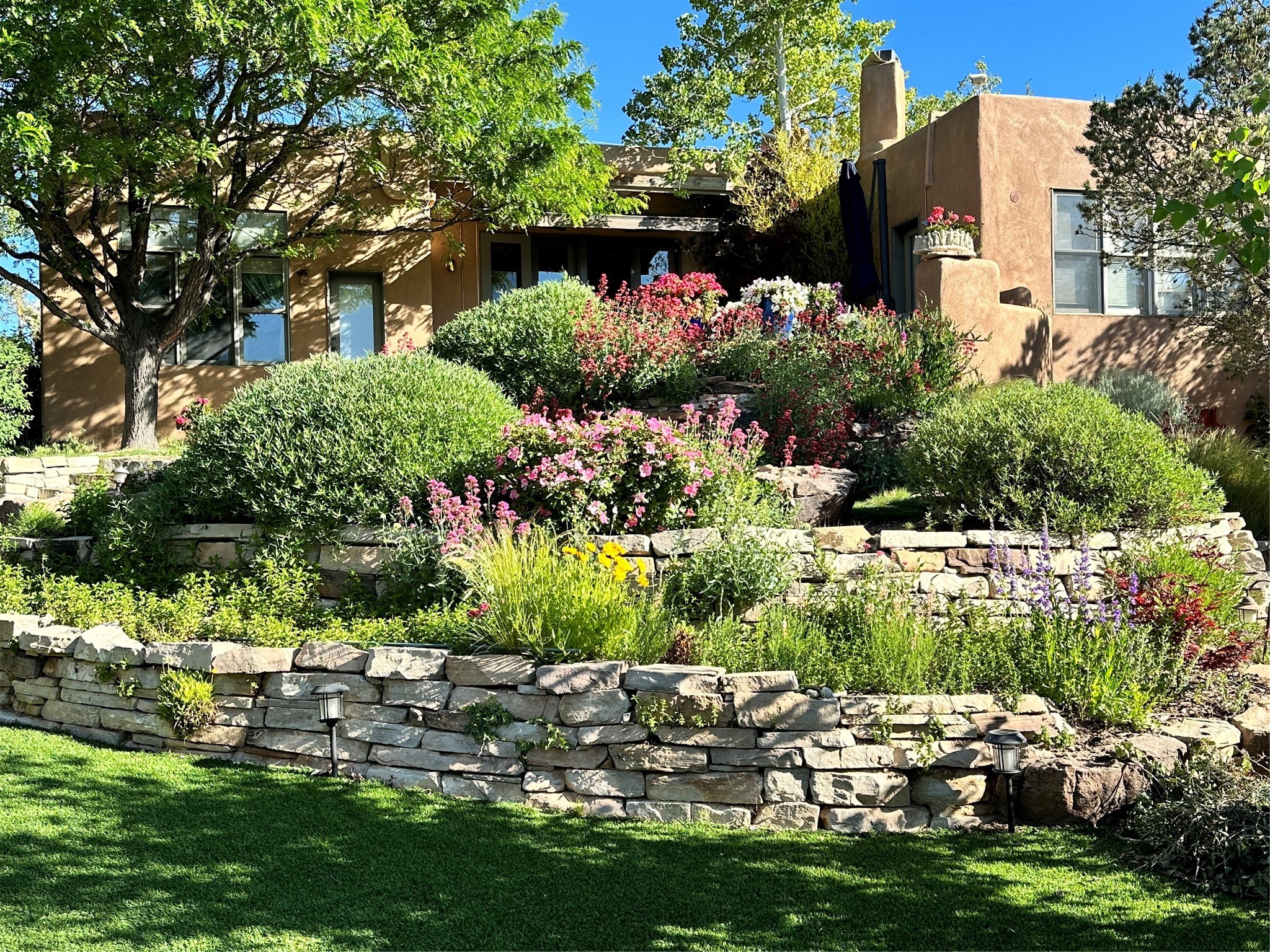 Perennial gardens, xeriscape, mature trees, and rock terraces