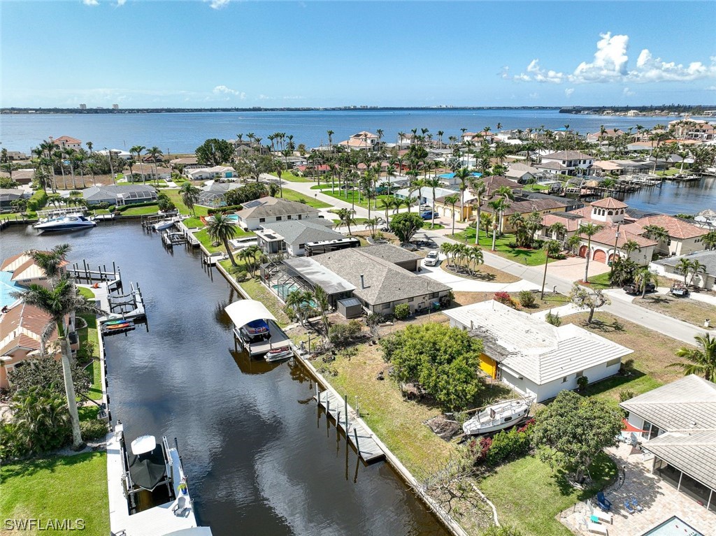 Location, Location, Location! This sailboat access home is in the Cape Coral Yacht Club Area & it is only a few minutes to open water.  This home is being sold at land value since it was damaged/flooded by Hurricane Ian and it has not been remediated.  Dock was also damaged so please don't walk on it.  This is a great location to build your new dream home or buy & hold for future investment.  This home is being sold AS IS - CASH ONLY!