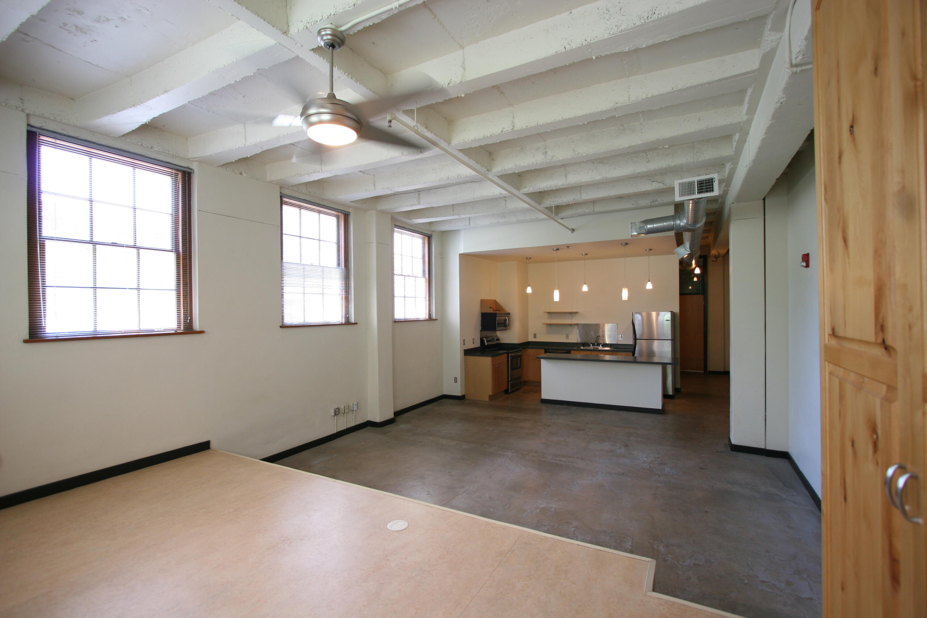 Approximately 914 sq ft, this corner-located ground-level loft in the 1939-built Gymnasium building at The Lofts at Albuquerque High features  2 east- and 3 south-facing operable windows, island kitchen with stainless steel appliances, concrete floors, concrete ceiling, full bath, and washer/dryer. Laundry/exercise facility/elevator in building. Access to beautifully landscaped secure courtyard with grill, fountains, and seating/umbrellas. Secure parking available in City-owned garage at 100 Arno for $40/month; free on-street parking. Condo Association allows dogs/cats/birds; no weight limit on dog; limit 2 pets. No AirBnBs allowed.