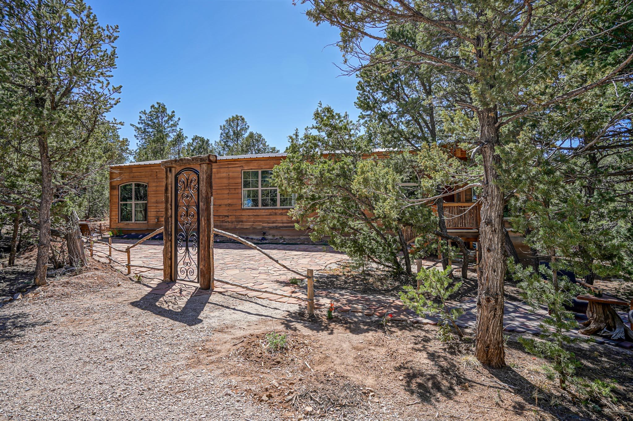 Escape the hustle & bustle to this beautiful 3 bed, 2 bath mountain home on 1-acre wooded lot full of rustic charm and unique features in a quiet Tijeras neighborhood. Large picture windows bring the outside in, variegated brick flooring throughout, wood ceilings, & latilla wood accents. Vintage ceiling fans from the Santa Fe Train Depot circulate REFRIGERATED AIR throughout the large living and dining areas. The home looks and feels like a cabin but was built to last with high end insulation to keep you comfortable & reduce utility bills. High speed internet and nearby cell tower keep you connected. Just a scenic 20-minute drive to ABQ & an hour to Santa Fe. Enjoy nearby skiing at the Sandia Crest & Santa Fe Ski Slopes. Fully furnished w/ many unique pieces! Would make a great BNB!