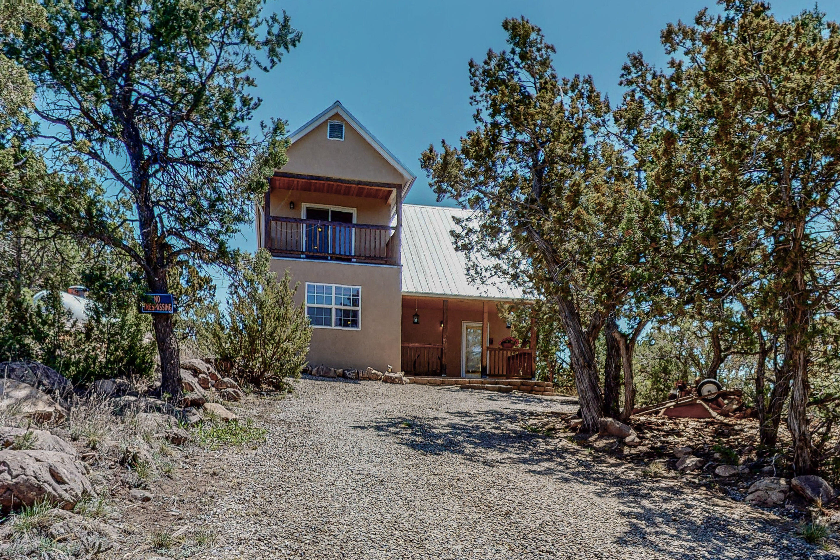 This beautiful custom home has views that cannot be beaten. Experience the peace of true mountain living less than 30 minutes from Albuquerque. The meticulously maintained northern New Mexico style home has two bedrooms, two full baths, high beamed ceilings, upgraded kitchen and bathroom countertops. The large master bedroom loft with a deck offers unsurpassed views and a walk-in closet. Other features include a pro panel roof, three split heating/air combo units, a wood-burning stove, radiant floor heat, outdoor storage shed, 20x20 detached garage,stucco 2020,new water lines, new advanced septic prior to closing & community water system. An additional .47 acre lot adjacent to the home can be purchased separately.(#385 Darby Lane).See MLS 1015393. Do not lock the security door in the back.