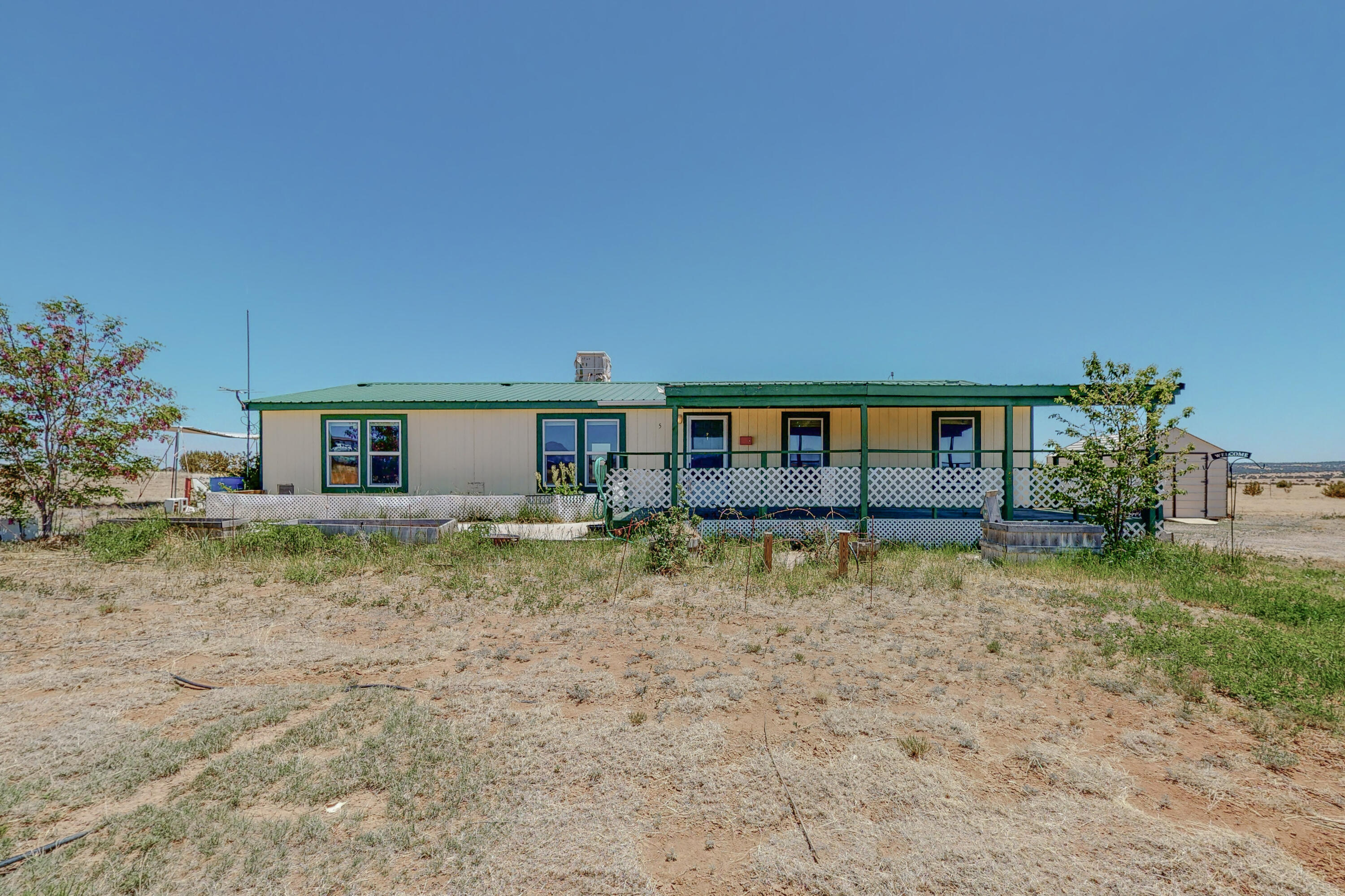Cute move-in ready Cavco home on 2.5 acres only minutes from Edgewood!  Close yet far out enough for peace and quiet and amazing New Mexico skies. Gorgeous 360 degree views.  Home has 3 bedrooms and 2 baths. Large front covered deck for relaxing after a long day.  New low-E windows installed in 2018.  Large 2.5 acres lot is level and perfect for gardening, a horse, or the type of country living you want to experience.  Lots of storage in huge primary bedroom closet.  Storage shed stays with property! Seller is offering a $2500 flooring credit upon closing. Real property/perm. foundation.
