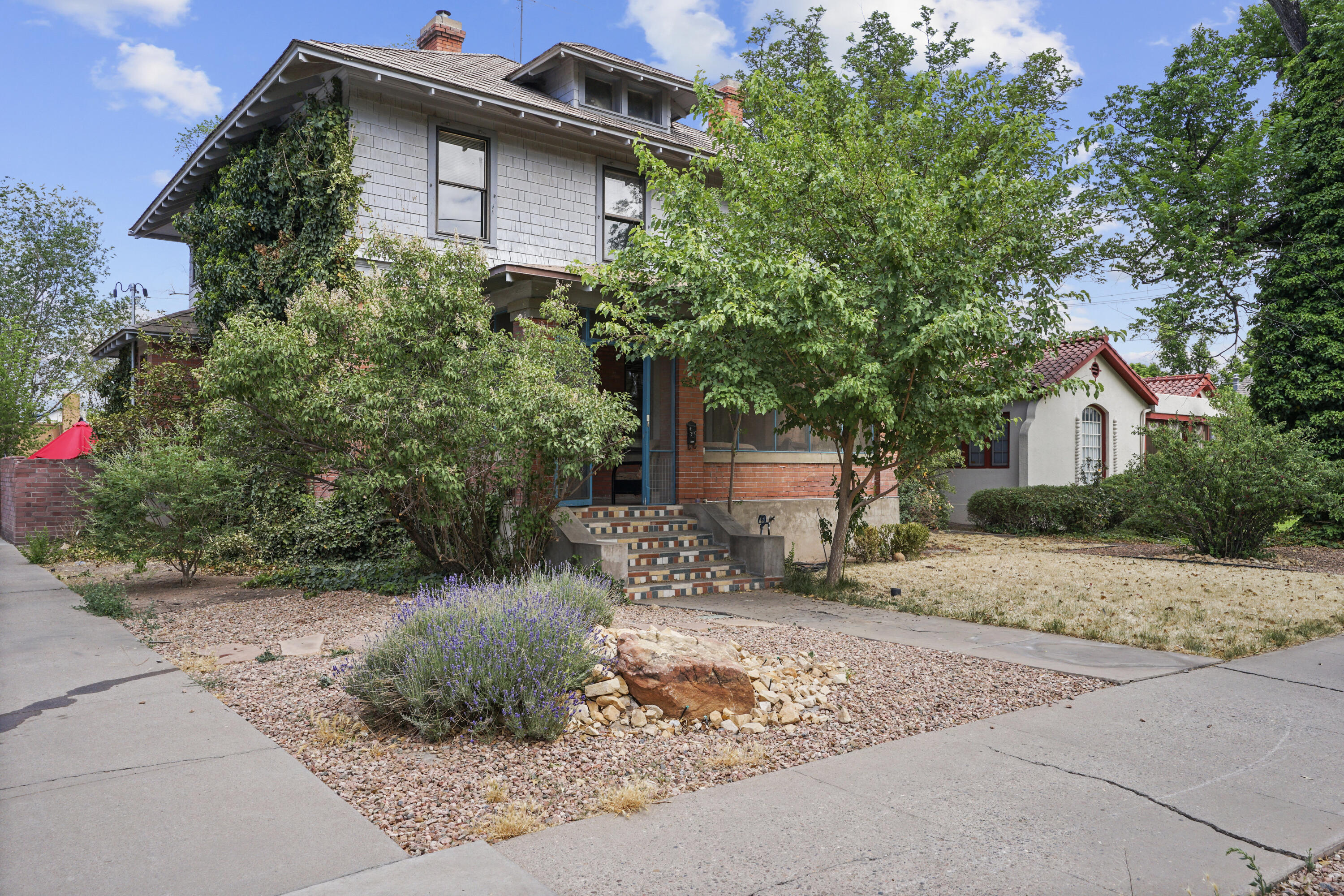 Located in Albuquerque's Historic Downtown Neighborhood! Situated on a large corner lot with mature shade trees! Built in 1915, this home is full of charming must-see details. There are two living areas, a formal dining room, a wood-burning brick fireplace, and Raised ceilings on the main level. Sliding pocket doors separate the living and dining space making it a perfect place to entertain. There are five bedrooms and one full bath located upstairs. You will also find an unfinished basement with Laundry hookups. An oversized window in the kitchen allows natural light to flow into the space as you cook your favorite meals. Relax on the screened-in front porch while enjoying a morning cup of coffee or evening sunset. Close distance to Old Town, Museums, Aquarium, Downtown, and Restaurants