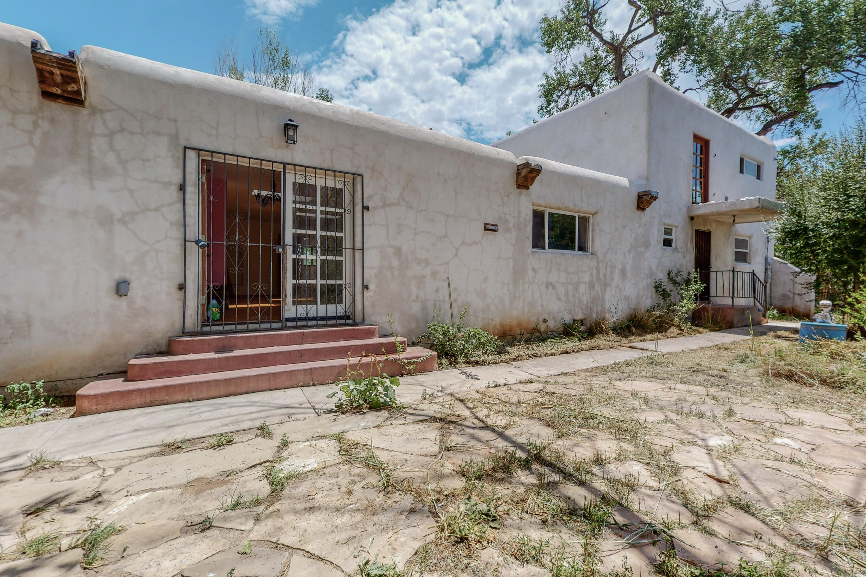 This is your opportunity to own a New Mexico True ranchito! The adobe walls of this 5 BR, 3 3/4 BA home, are heated by two, wood burning, kiva fireplaces. The home has space off of the garage that can be utilized as a workshop or office. The space has a separate entrance and has a sink, countertop space and a full bathroom. There is an adobe casita that contains 1 bedroom, a full bath, kitchen and living room. The property is situated on 1.34 acres and comes with Pre 1907 water rights! There's more! There's a barn, chicken coop and small orchard containing apple, pear, cherry and pomegranate trees.  Peacocks regularly frequent the property. The roof on the main house and guest house were replaced in 2014. If interested in owning your own piece of a truly New Mexican home, look no further!
