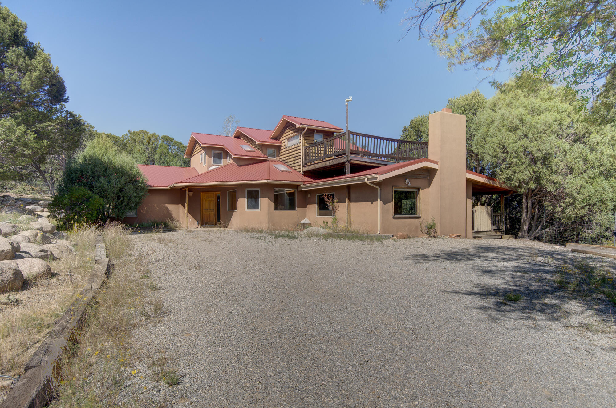 This spacious home is situated in a cozy wooded area with beautiful views of Cedro Peak. With large rooms and beautiful views, this home has endless potential. Unique Southwestern elements give this home character.