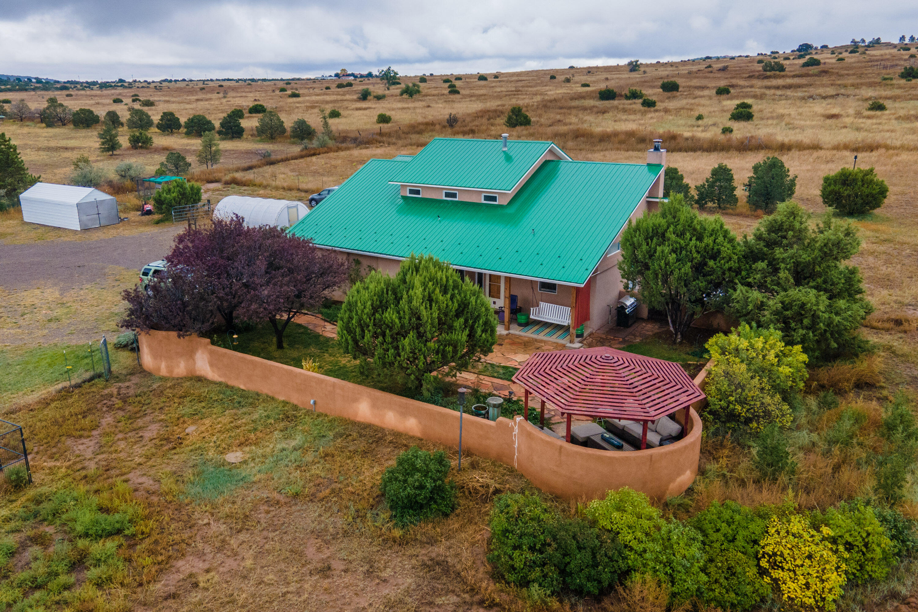OPEN SUN 12/4- 12-3 pm. This gorgeous property consists of 5 beautiful acres (2.5 acres fenced) with a large main house boasting 3 beds, 2 full baths (1927 sq ft) and nearby casita with 1 bed, full bath and kitchen (659 sq ft). Perfect for multi generational living or a great rental opportunity. Built with passive solar, cross ventilation cooling, & 12'' thick walls, the main house has energy efficiency, and incredible mountain views.  It is also open concept with soaring ceilings. The casita is fully functional & cozy. Close to I-40, with Comcast internet, lovely outdoor living spaces & greenhouse gardens, this property is versatile, turnkey & comprehensive to all your mountain living dreams. Water heater, furnace & stove replaced in 2021. Come make this lovely property your mountain home