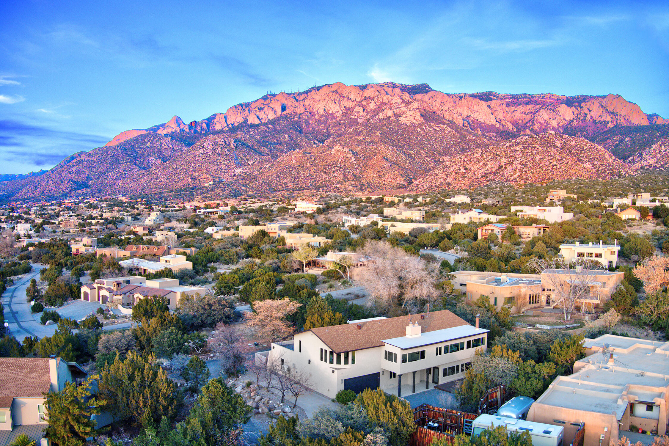 ***OPEN HOUSE Sat & Sun 12/3 & 12/4 1pm-3pm*** World class; everything a luxury home should be! Come experience the pinnacle of fine living perched high in the foothills of the majestic Sandia Mountains overlooking Albuquerque complete w/palatial mountain views capitalized from enormous picture windows. Ascend the road towards the mountain to the residence and you will be delighted by friendly residents walking & waving, half a dozen deer frolicking, and the sweet signature New Mexican aroma from the picturesque Pinon trees. Cross the regal threshold and you will feel the quality. Masterfully-designed floorplan w/guest house, home gym w/shower svc, inspirational office w/outdoor views, big loft & wet bar, luxurious sunroom, and easy-care outdoor living on spacious balconies. SUNSETS GALORE