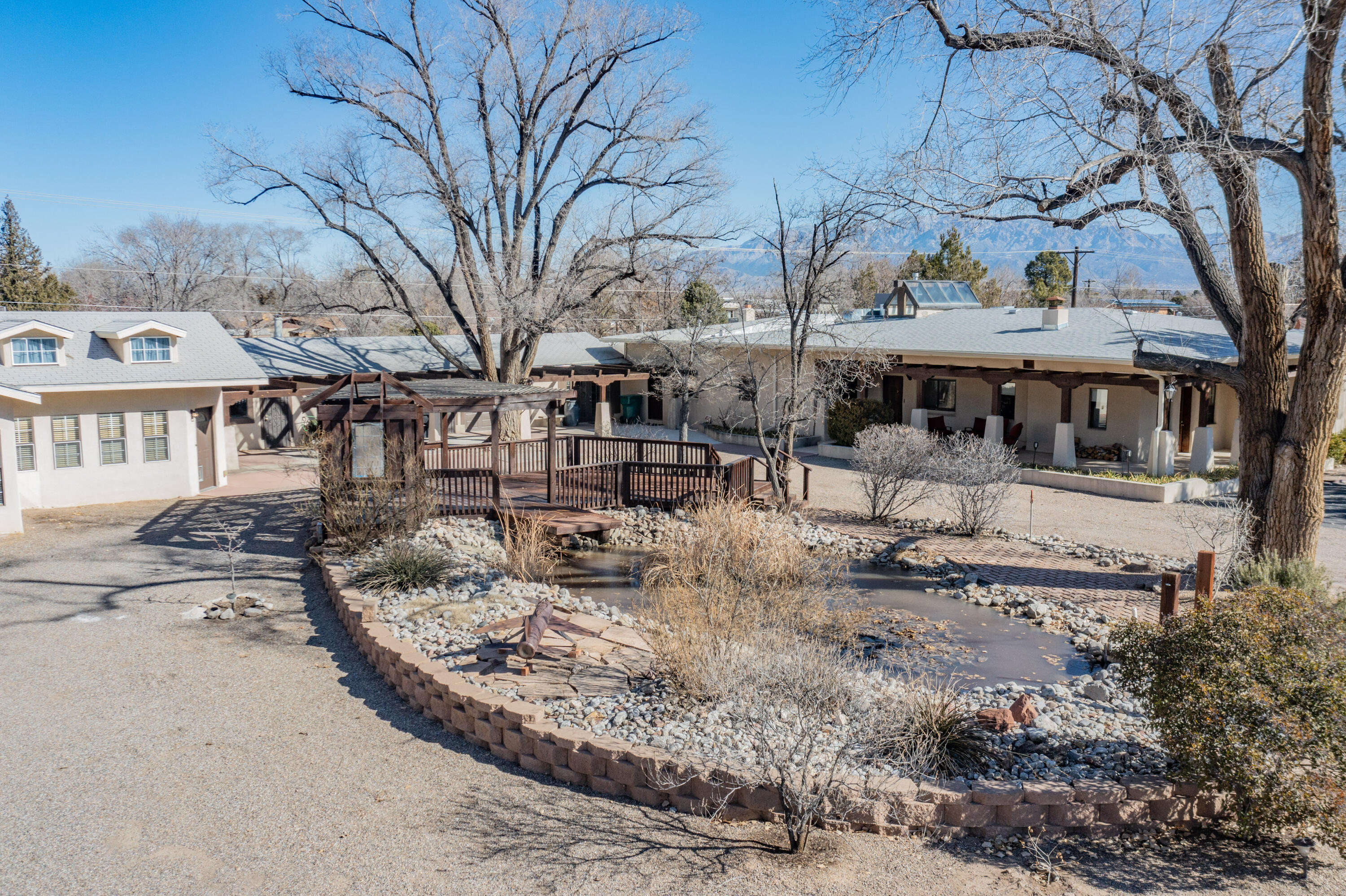 Here's a rare opportunity to take a step back in time and own a little piece of Albuquerque history.  This uniquely elegant, turn-of-the-century, pool home is nestled beneath mighty cottonwoods and is constructed out of 18'' thick hand-honed ''Terrone'' Adobe. The main home, built in 1930, features a split bedroom floor plan and has been lovingly maintained and updated. You'll enjoy coming home to your cathedral skylight, chef-inspired KitchenAid kitchen and spa-inspired marble clad primary ensuite.  The original oak floors are perfectly flanked by the rough sawn oak ceilings and beams.  The square footage includes a 2002, 1200 sf  2bed 2bath full-kitchen guesthouse.  The 1 acre of walled and fenced land comes complete with a newly resurfaced heated gunite pool, and more. Cont. on attached