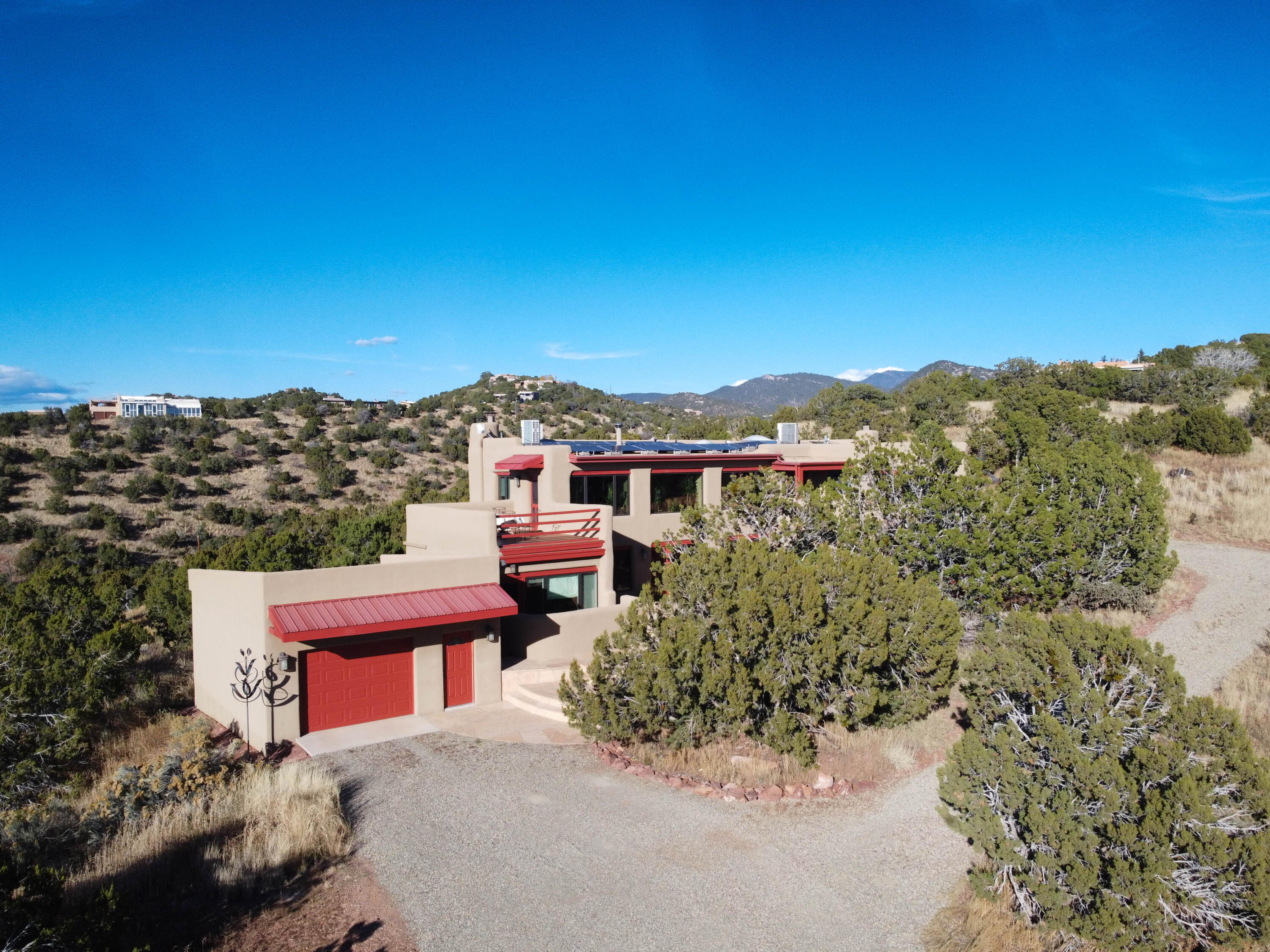Majestically situated on Santa Fe's southeast foothills atop your own prestigious lot on over 5 acres  in Seton Village is this artistic custom adobe southwestern estate. These are next level views that immerse you in the Enchantment of New Mexico.  This home has character, style, and flare with an extensive list of upgrades. Featuring remodeled chefs' kitchen, updated gorgeous bathrooms, designer touches throughout, newer roof, stucco, windows and more. The passive and active owned solar design makes the home ultra-efficient coupled with updated heating and ventilation system and a tankless water heater. Large, 1.5 garage could be workshop or home gym. Beaming with pride of ownership do not miss an opportunity to live in one of Santa Fe's finest only 15 minutes to the famous Plaza