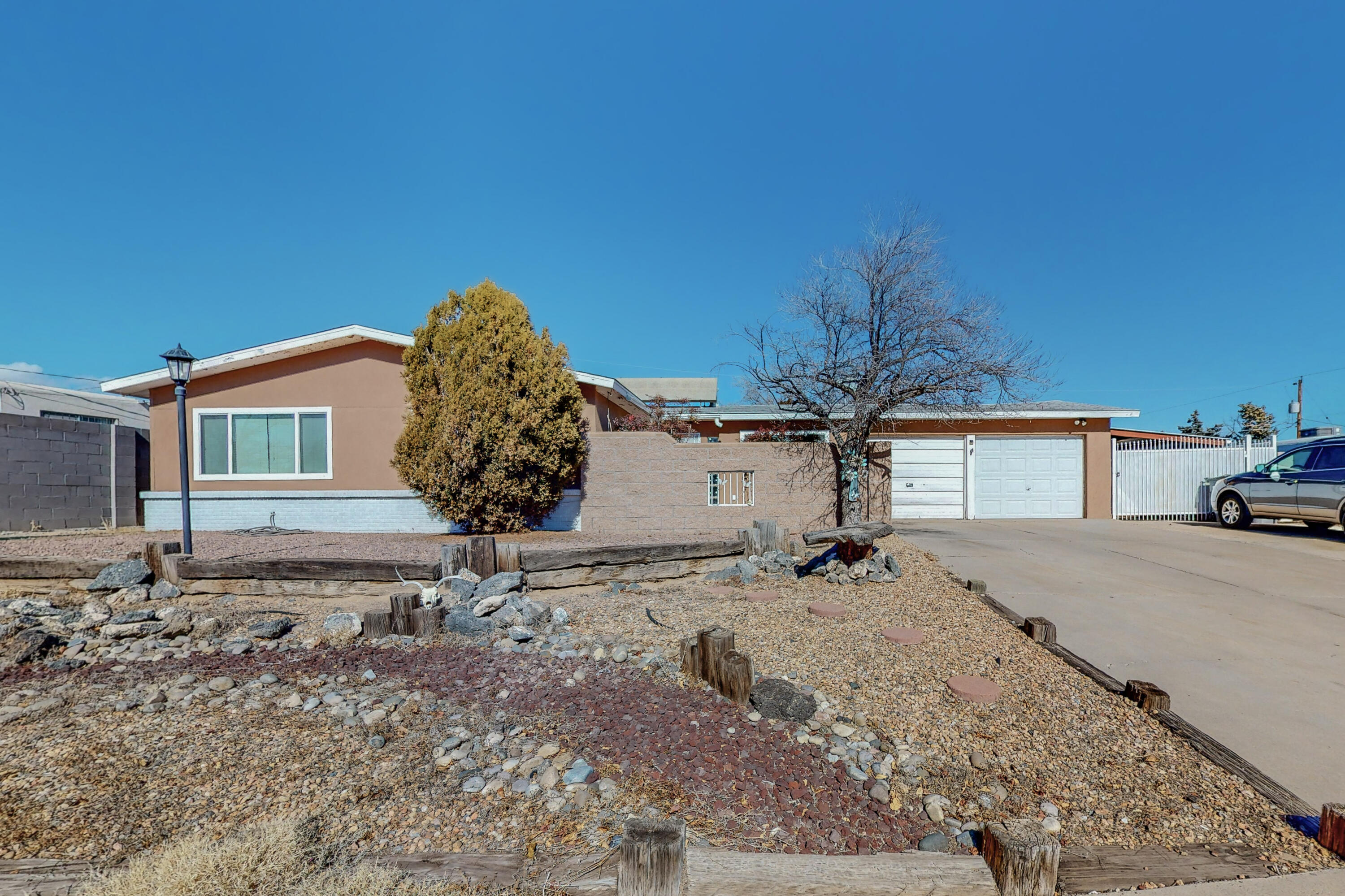What a great opportunity in NW Albuquerque! This home features .23 of an acre lot, a front courtyard, two car garage, side yard access, an upper backyard patio area, and a lower area with a basketball court! Inside features 2 living areas, hardwood tile and carpet floors, wood burning fireplace, and refrigerated air conditioning! Call today to find out how to make this home yours today!