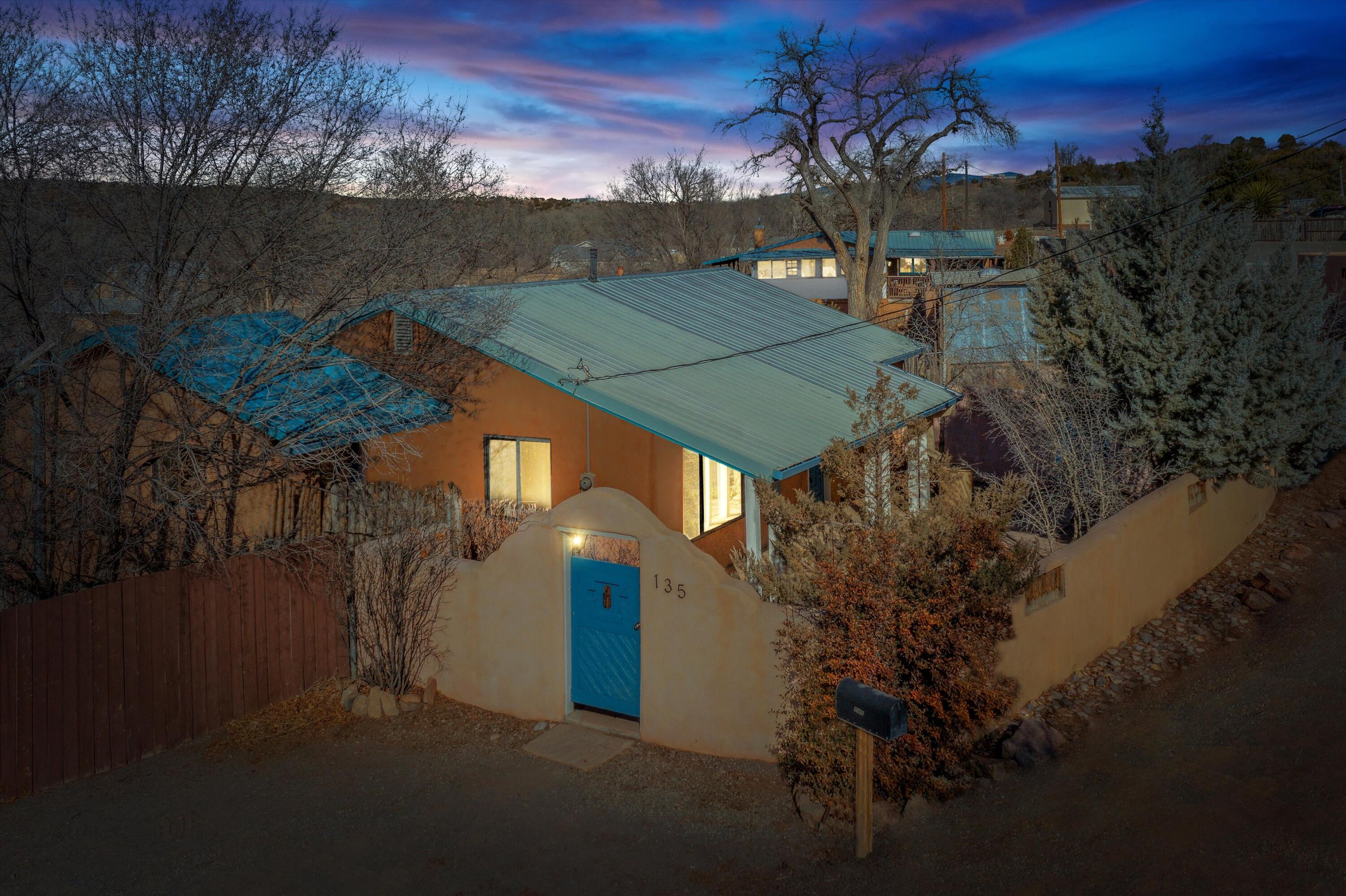 The spirit of New Mexico True in La Cienega. Flagstone patio to the large wooden deck, your choice for morning coffee or evening refreshments. Step inside to a sunny and bright home with original hardwood floors, modern kitchen and baths, & inviting views from every room. A Northern NM style home with metal roof ready to be adorned. Property is on community water, tankless H2O heater, baseboard radiant zoned heat with natural gas boiler. Beautiful appliance package including washer and dryer. Septic tank replaced in 2015 PLUS a stand up height basement-not incl. in sqft runs the full length of the house at an 8' width. Very usable space that can be finished out to be a workshop or hobby space. 30 MIN to Abq. or LA. The Plaza 15 min. Only 5 minutes from Ojo Santa Fe Spa. Now this is living!