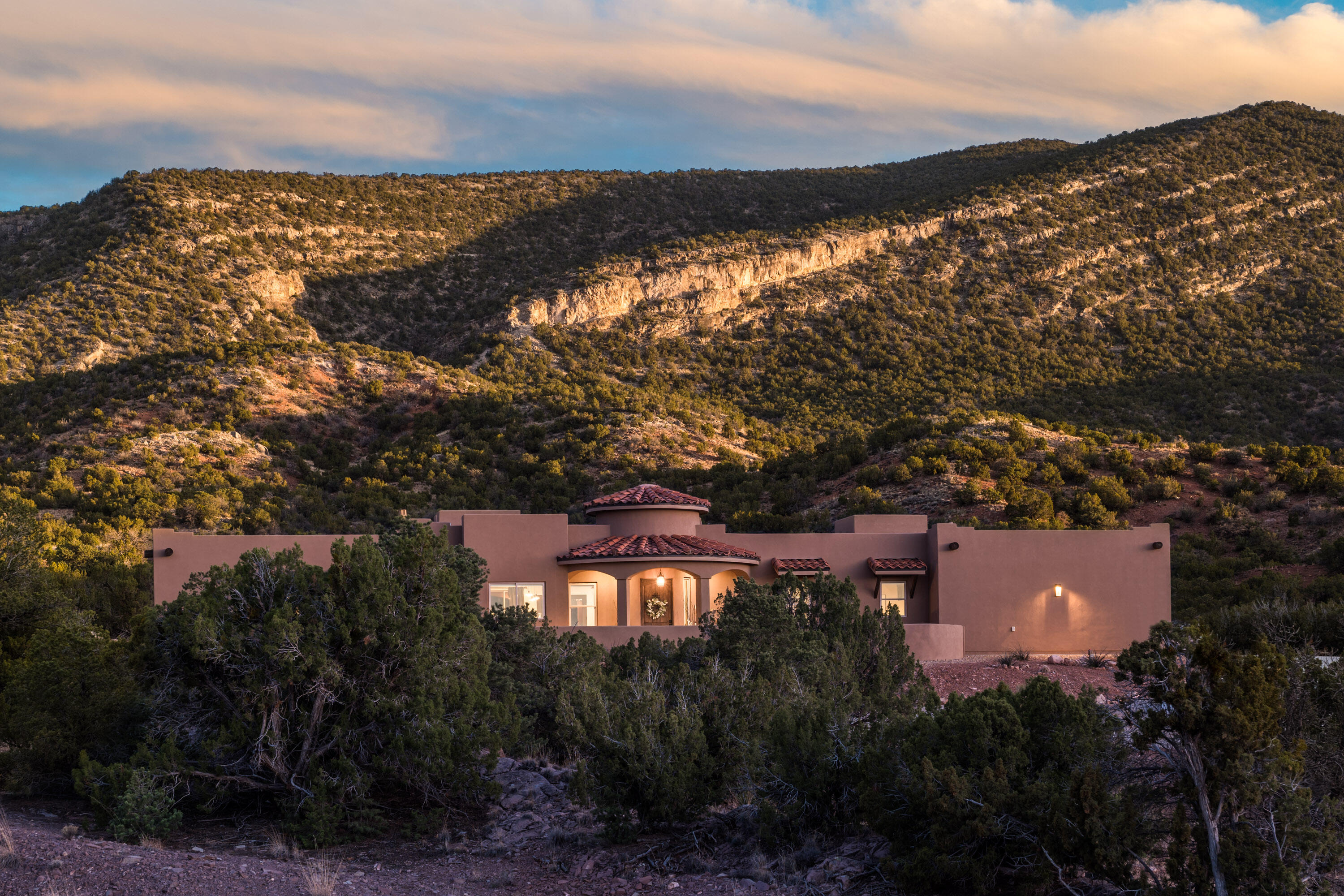 Impressive 3-year young custom home on 3 acres just a short walk to the Cibola National Forest trails. Thoughtfully designed split floor plan with Sandia and Jemez Mountain views thru large windows. Beautiful entry with custom chandelier, spacious great room w/high wood-beam ceilings & gas log fireplace. Inviting kitchen w/custom soft-close cabinetry, leathered granite counters, island w/bar seating, Frigidaire Cafe series appliances, coffee bar & walk-in pantry. Primary suite features custom tile shower, porcelain clawfoot tub, double sinks, large walk-in closet and patio access to spa area. All tile flooring, 3BR/2.5BA with oversized 1127SF 3-car garage, 3rd bay w/pull-through doors, 220 electrical. Covered patios w/kitchen area offering private, unobstructed Sandia view. See the video!