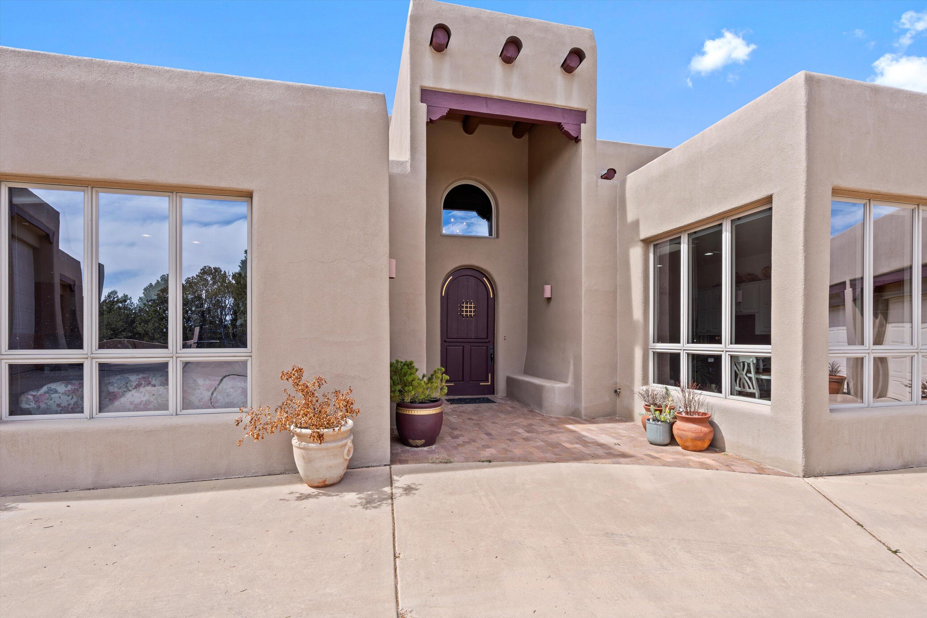 AMAZING MOUNTAIN RETREAT! 20 MINUTES TO ABQ! OWNED SOLAR! This gorgeous, well maintained property is walled for privacy and security. Custom entry doors open to a great room with airy 17' ceilings. Windows accentuate the living space and mountain beauty. The Chef's Kitchen is spacious & has ample cabinet space w/thoughtful design touches. Double Oven, Granite countertops, new Samsung refrigerator, large center island, wine frig and spice rack are just a few of the touches of this functional design! 3 car attached garage is great AND the BONUS RV garage parking for 3 add'l motor vehjcles  & work space. A car collector or handyman's dream! The Primary bedroom is spacious and includes a comfy and well lit bonus sitting room! The primary bathroom has a large double shower, soaking tub, and 2 v