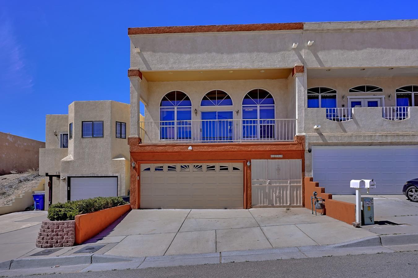 Townhome nestled in the heart of Albuquerque. Panoramic Views of the Sandia Mountains & the city skyline/glittering night lights. Main level offers an open, light, floorplan overlooking the balcony with breathtaking views. Great room has ventless FP, raised ceilings overlooking Chef's kitchen with granite countertops, adequate counter space and cabinets. Owner's suite features a walk-in closet, cozy FP, oversized jetted tub with backyard access. 2br's, up, 1br,, down (entry level) has a door from the garage, separate access, 3/4 bath, private. Great for entertaining with this open floor plan, step out to the deck and sip cocktails under the stars. 3 zone radiant heat. ALL FURNITURE CONVEYS, including the 65'' TV. GREAT AIRBNB OPPORTUNITY. Close to stores, frwy.