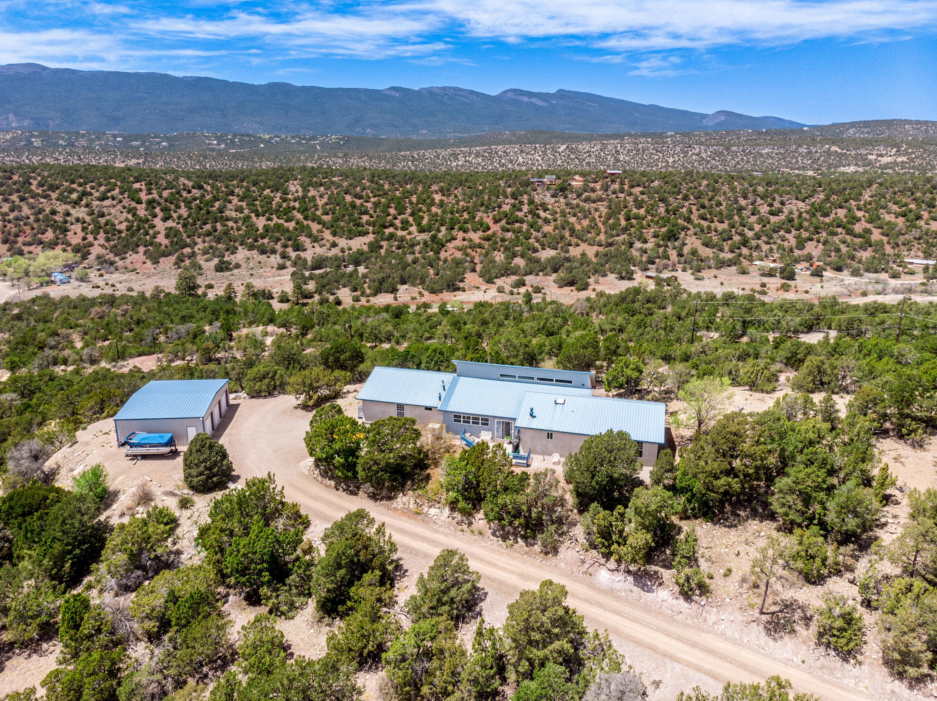 This charming 3-bedroom, 2-bathroom home is located on its own private mountain top in Tijeras. The home sits on a spacious lot with mature trees and natural landscaping providing plenty of privacy and shade. Inside the home features an open floor plan with a cozy pellet stove in the living room and a large deck off the dining area, perfect for entertaining. Plenty of room for toys or hobbies in the 3-car detached garage/shop. Located just minutes from hiking trails and other outdoor recreation opportunities. This home is the perfect retreat for those seeking a peaceful escape from the city.