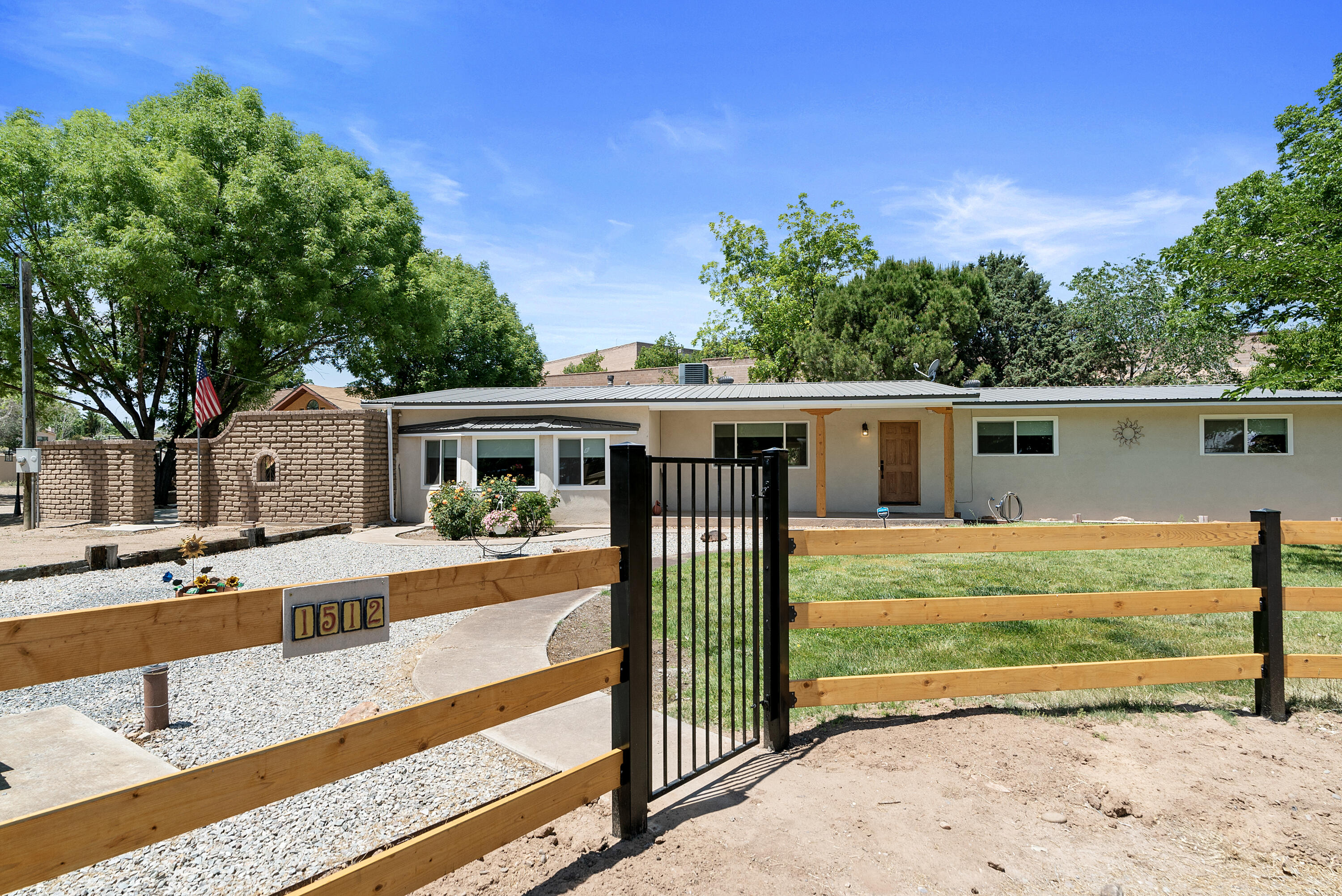 Welcome to your dream home in North Valley! Horses welcome! Remodeled ranch home on 1.24 acres with grass, fruit trees, Acequia trail access, horse stalls, and a workshop with added living space upstairs. The heart of the home is the newer kitchen, boasting ceiling-height cabinets, elegant granite countertops, and state-of-the-art black stainless steel appliances. The custom subway tile backsplash adds a touch of sophistication to this culinary haven. There's a bonus hobby room that's flooded with sunlight, along with a sunroom. Newer stucco, Pella windows, mini splits and HVAC, and the property is fully fenced with an electric gate. Great location, rural yet minutes to I-25, great restaurants, and shopping. This is the perfect setting to enjoy and make memories. Make it yours!