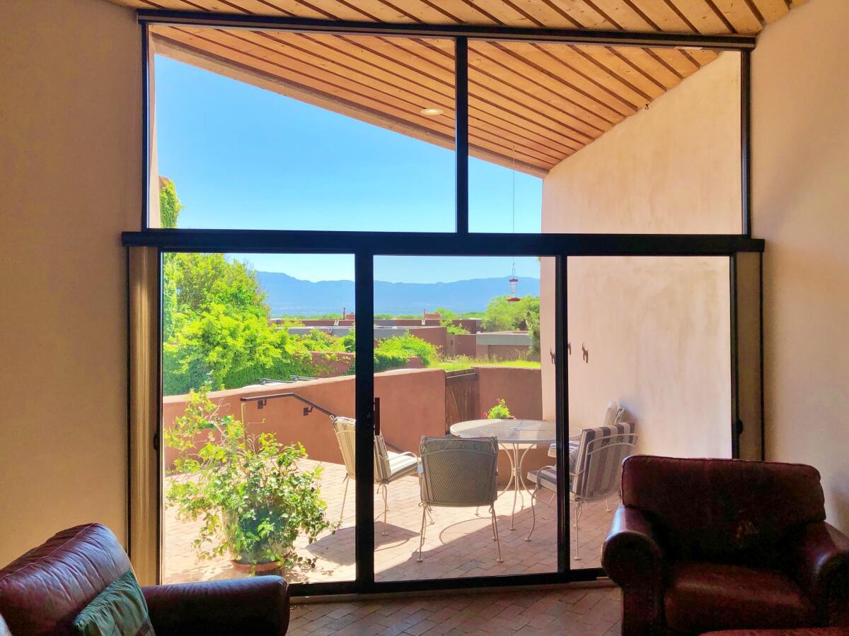 La Dolce Vita--live the sweet & easy life in La Luz. Marvel at the stunning views, appreciate the unique adobe architecture by world-renowned architect Antoine Predock, & relax in your lush private courtyard at 12 Pool St NW. The home is an end unit, adjacent to the forever Open Space acres between La Luz & the Rio Grande Bosque. Enjoy the spacious living room with Kiva fireplace, sweet public area brick floors, wood slat ceilings, numerous skylights, cooling sunshades, deep hall pantry, 2 courtyards & the Primary bedroom view balcony; the bathrooms have been remodeled featuring cool tile & dual vanities. An interior spiral staircase takes you to the garage. Plus: community tennis courts & Olympic-sized pool, with 5+ acres of tended gardens & greenspaces. See the 3D Tour, then come see!