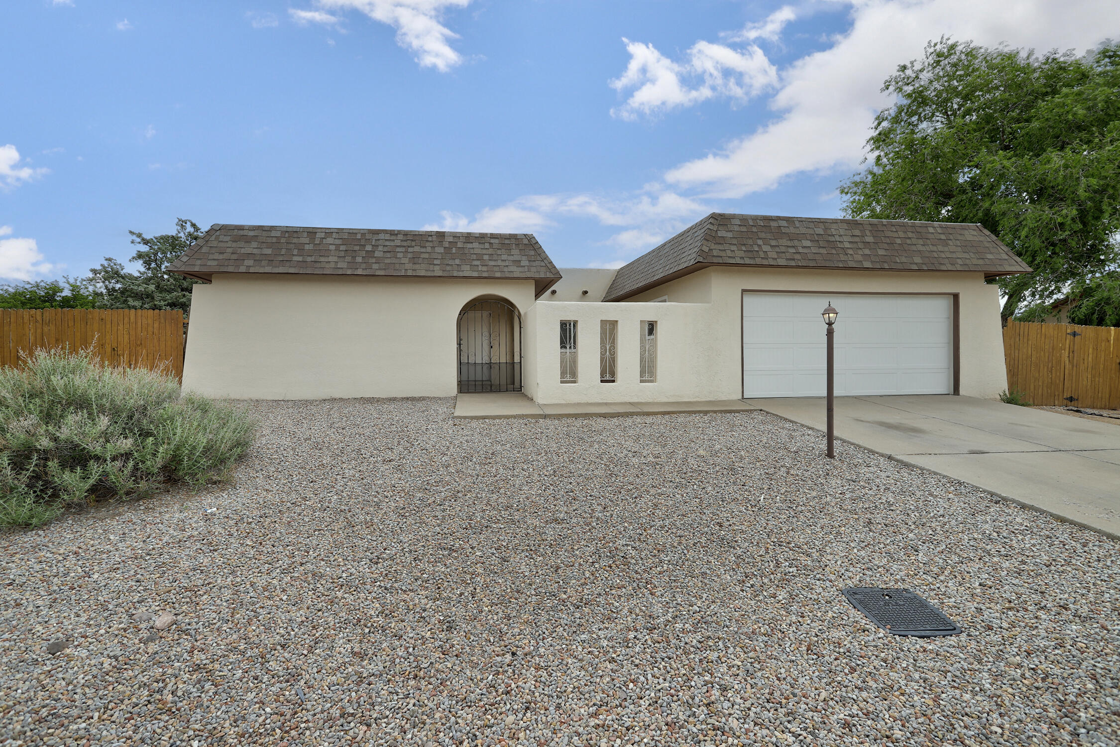 This Rolling Hills home invites you in with a welcoming open floor plan, cozy fireplace and beautiful laminate flooring. The open kitchen features granite countertops, tile backsplash, and stainless steel appliances. 3 bedrooms with spacious closets with built in shelving & one full bath and one 3/4 bath. Secure front courtyard and a large backyard boasting backyard access - room for your RV or trailer! Two car garage. Easy access to Unser & less than a mile to shopping and restaurants. This Rio Rancho gem won't last long!