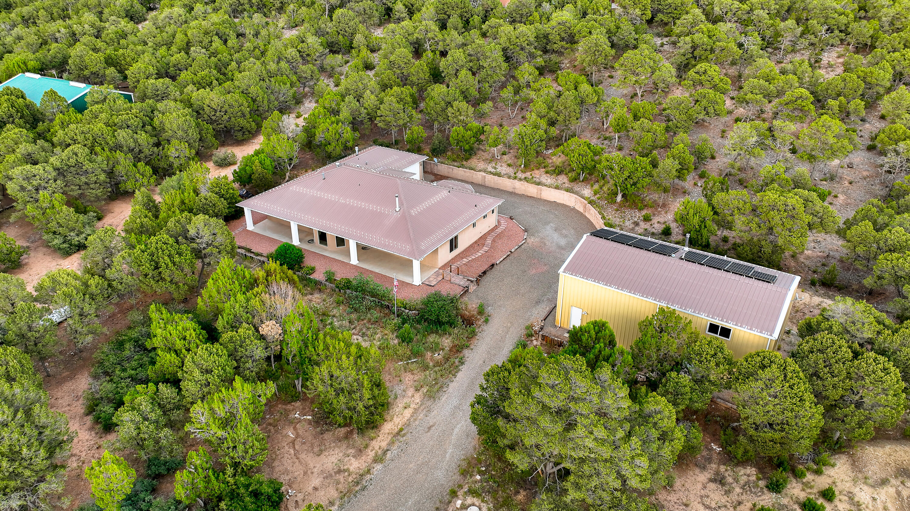 Nestled amidst the picturesque landscapes of Tijeras, New Mexico, this captivating property offers a harmonious blend of rustic charm and modern comfort. BRING YOUR HORSES! Ensconced on 4.5 wooded acres, fenced & gated. Solar Power 7.2 Kw 2019, Seller pays off at Closing. Light open plan, 9' ceilings, tile throughout. Kitchen features granite countertops, hardwood maple cabinets, double oven, gas range & island with ample counter space. Radiant floor heat, wood burning stove and solid maple doors. 1500 SqFt Steel Shop with 220 Volt service, finished insulated interior workshop/studio features 3/4 bath & walk-in closet. Generously sized back patio is an ideal space for al fresco dining, entertaining, or simply unwinding while taking in the breathtaking vistas of the New Mexico landscape.