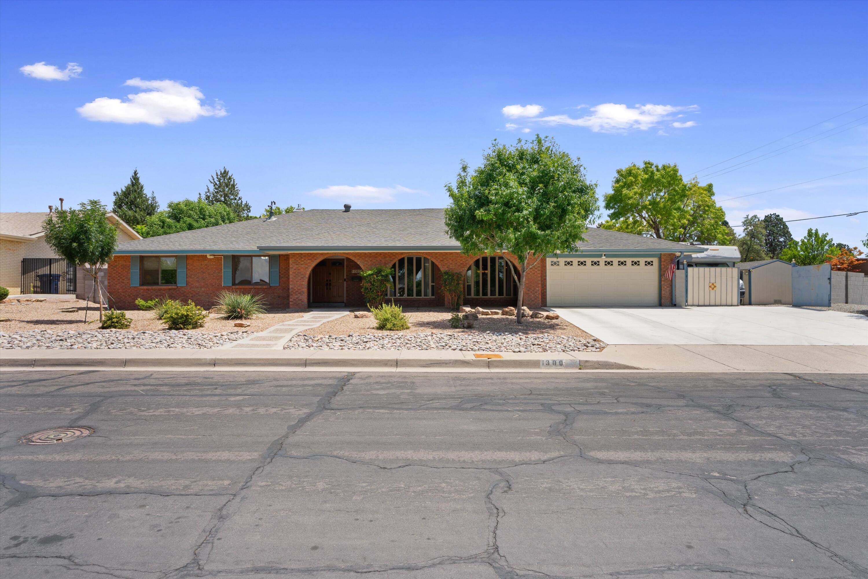 Gorgeous single level brick home in highly coveted Altura Park Neighborhood! This corner lot beauty is the entertainers delight featuring a swimming pool/hot tub, backyard access, & RV pad/hookup! Oversized driveway & large covered front patio welcome you into this spacious home. Functional floorplan includes two living areas, formal dining, huge laundry room w/ lots of storage space & gorgeous kitchen w/ granite countertops & tons cabinets. Other updates include, new mini split units/refrigerated air, tankless water heaters, & new bay windows. Living room has high wood-beamed ceilings, wet bar & gas log fireplace. Private backyard is perfect for hosting guests, gardening, soaking in the  pool or relaxing by the water feature. Close to Nob Hill, UNM, shopping & parks. Don't miss this one!