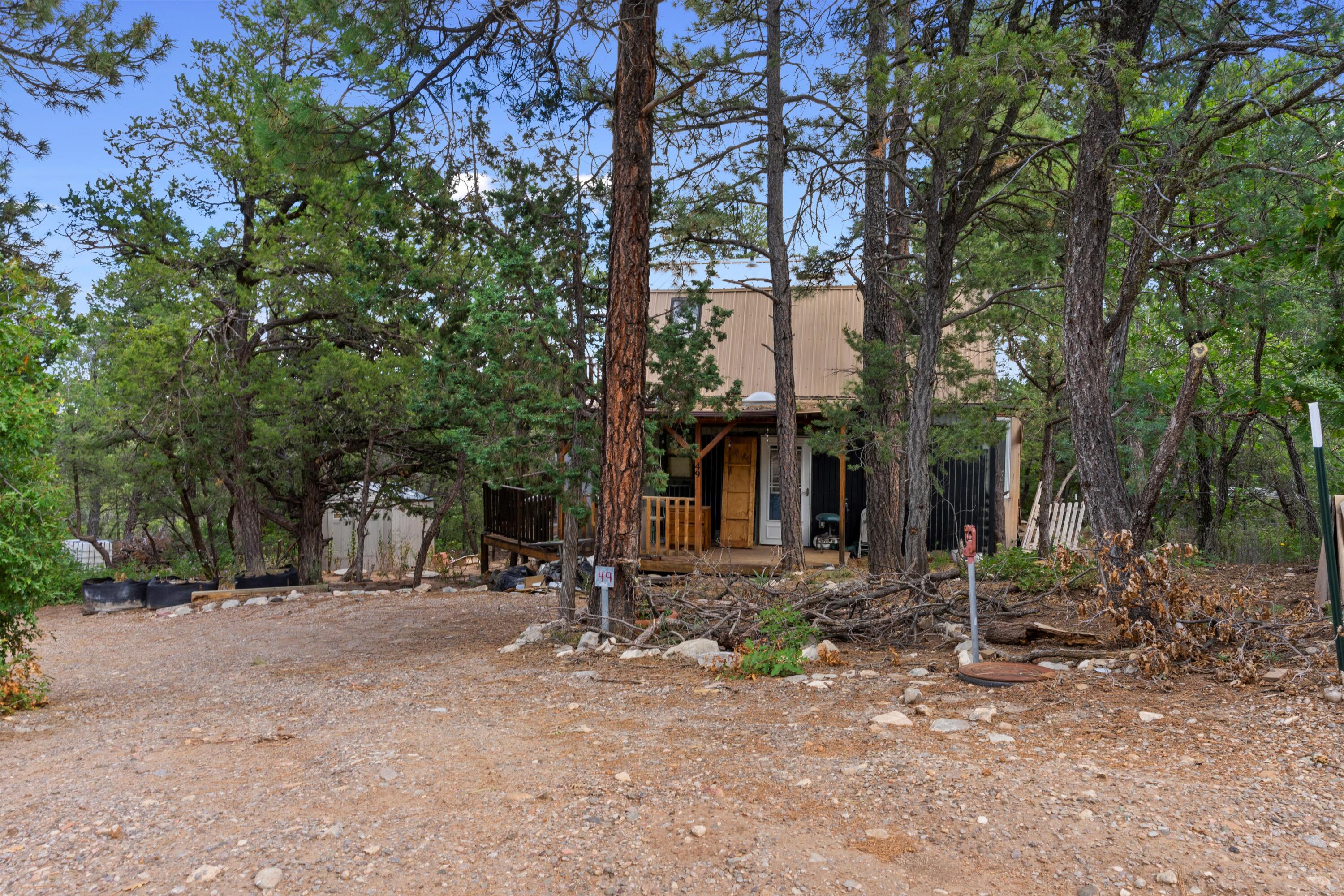 Welcome to this tranquil 1 acre property nestled among the majestic ponderosa pines. This charming cabin combines the serene beauty of nature with the cozy comfort of a 2-story retreat with its inviting porch that wraps around the house, offers a tranquil retreat with 2 bedrooms with the opportunity to grow. This 1026 square foot cabin offers a peaceful sanctuary in a picturesque setting. The living area is a cozy space, perfect for relaxation or gathering. Large windows allow natural light to filter in, creating a bright and inviting ambiance. The one-acre property allows ample space to create outdoor living areas, gardens, or simply bask in the tranquility of the natural surroundings. Must see in person to experience the mountain air and see the potential of what your TLC could do!