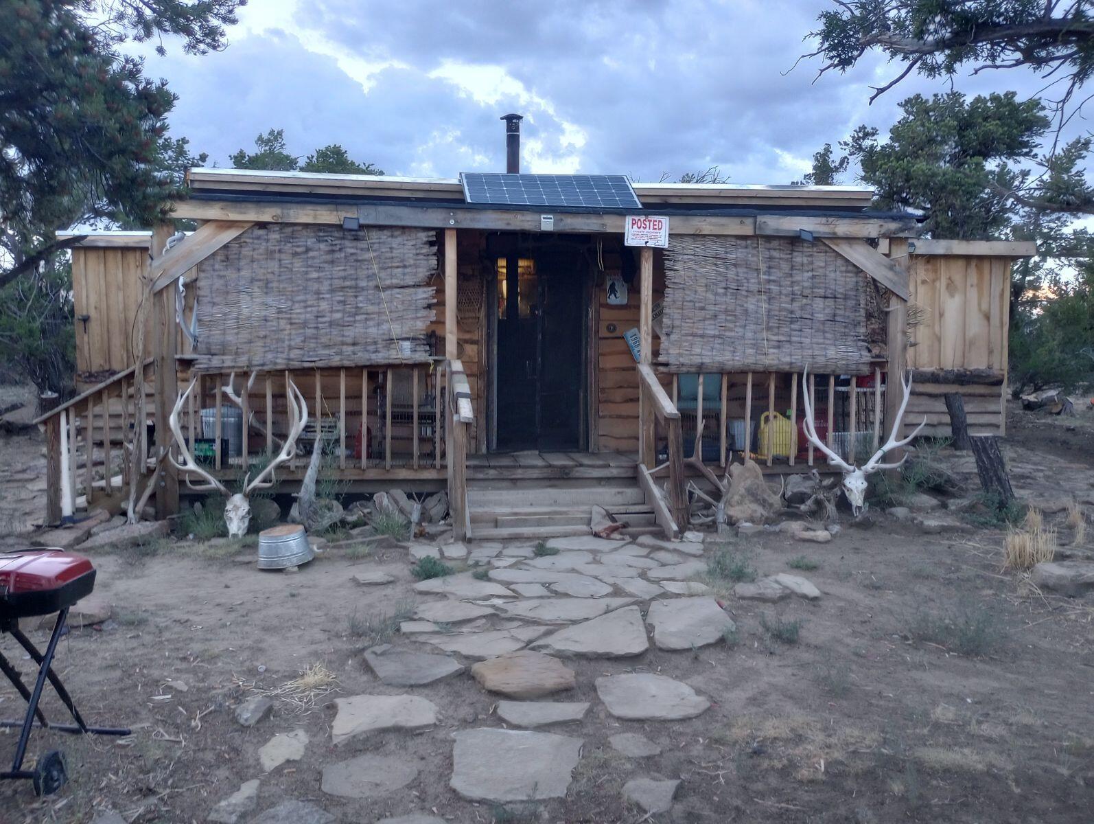 Peace, quiet and beautiful views are found here. From this beautiful lot with pinon and alligator juniper trees throughout. There is an off grid site built cabin constructed of hand hewn logs from the area and a wood burning stove for heat. There is a shed for storage, a loafing shed with an attached corral, nice out door area for viewing the amazing views of the sunrises, sunset and night skies. Numerous rock outcroppings, inculding one large enough to be a natural hot tub. The Sawtooth mountai range can be seen while walking through the trail system or climbing on the rocks. The seller has the adjoing lot for sale as well ans is willing to offer a discount if both lots are purchased together. Don't miss this oppotunity to own an amazing getaway home or permanent residence.