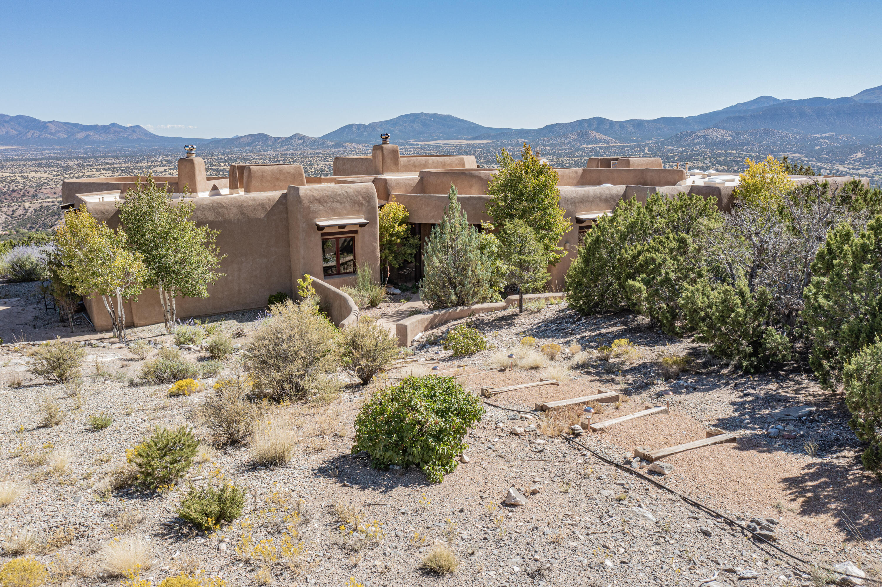 Nestled in the enchanting landscape of Sandia Park, New Mexico, this exceptional home on 10 Acres is a testament to luxury living. From its meticulously southwestern  designed interiors to its captivating surroundings. Every facet of this home has been crafted to provide an unparalleled living experience. From the moment you walk through the front door you are captivated by the amazing panoramic view of the San Pedro, Ortiz, Sangre de Cristo & Jemez Mountains. The gourmet kitchen is a chef's delight, featuring high-end appliances wolf gas range, sub zero refrigerator, custom alder cabinetry, and granite countertops with thick chiseled edges. Imagine preparing culinary masterpieces while enjoying panoramic views of the surrounding landscape. Beautiful travertine tile and hardwood flooring.