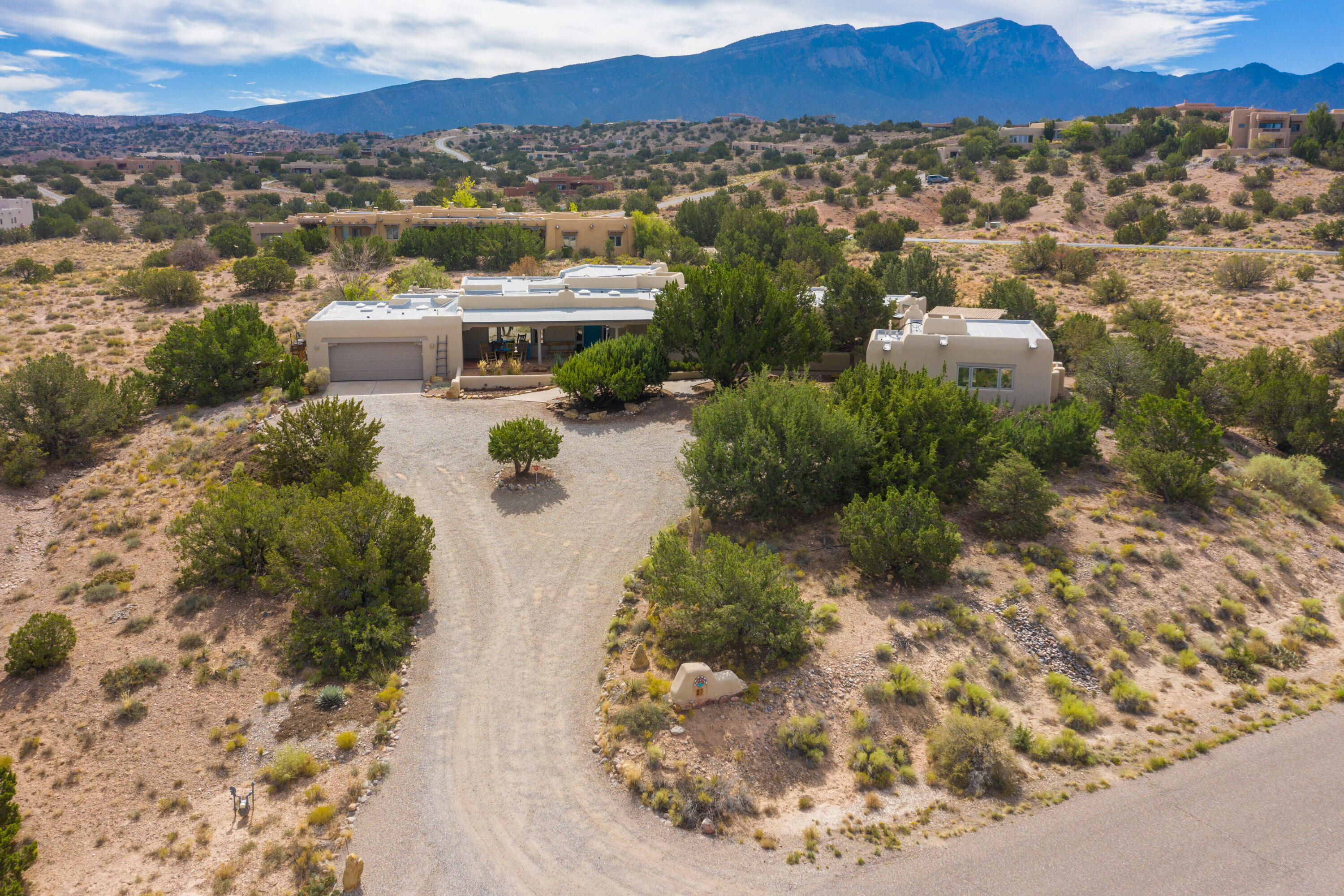 Quintessential Placitas adobe custom, single level home on 1.9+ acres lot in La Mesa. Exquisite finishes included exposed adobe walls, brick floors w/radiant heat, wood beam ceilings, 5 kiva fireplaces, nichos & bancos. Detached casita w/ensuite bath, kiva fireplace, brick floors, diamond finished walls & tankless water heater. Primary suite w/kiva fireplace, private covered patio, his/her closets, jet tub & separate shower. Kitchen w/butcher block island, breakfast nook w/banco & walk-in pantry. Outdoor living awaits w/multiple covered patios, fireplace, mature landscaping w/fruit trees. Recent updates include new stucco (2020), new roof (2020), skylights, exterior paint, mini-splits HVAC (2021), plus new oven, dishwasher & refrigerator. Southwestern living at its finest - welcome home!