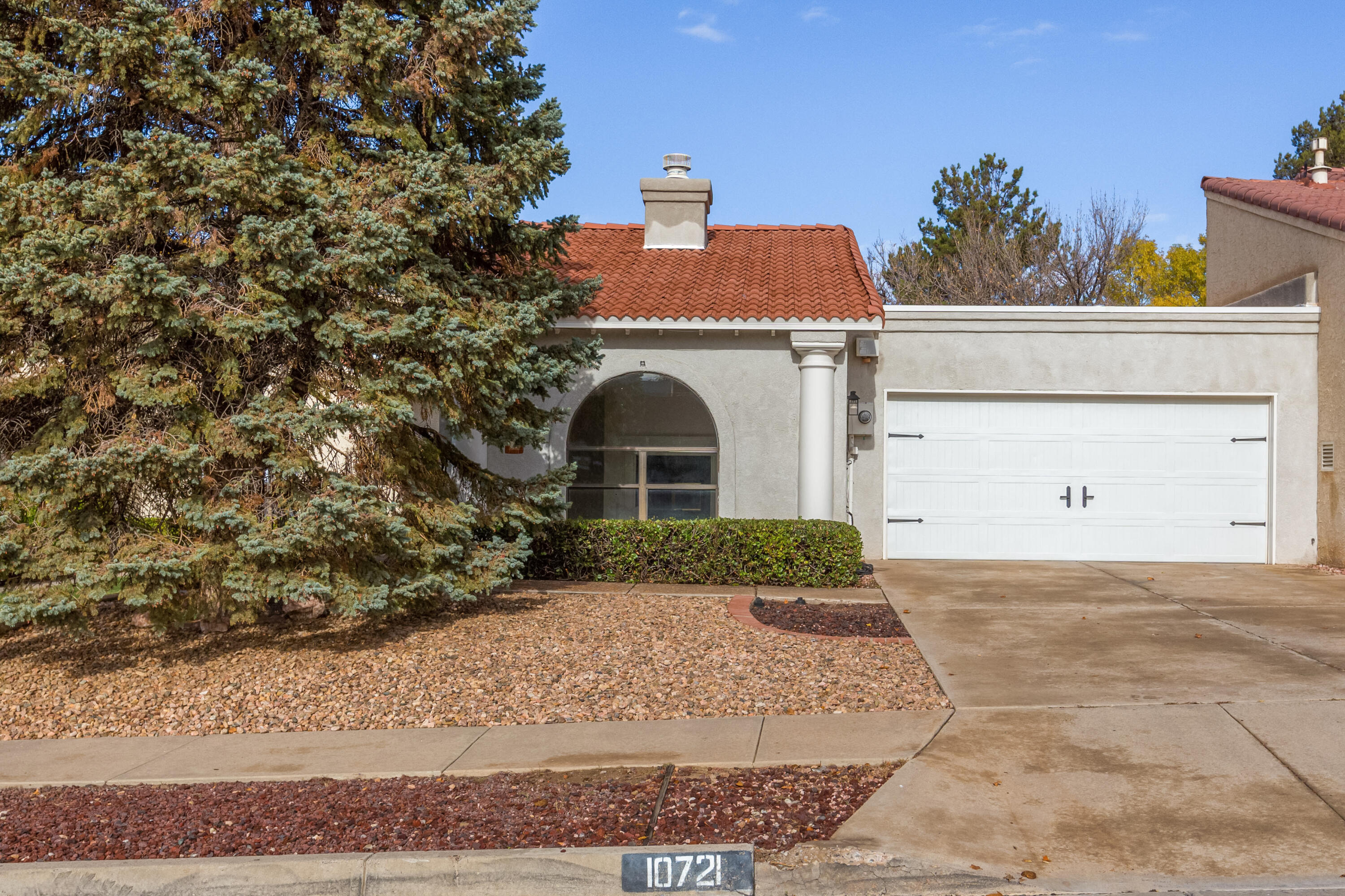 Fall in Love w/this single level far North East Heights gem, located in a sought after neighborhood near the foothills, walking trails, parks, grocery shopping, restaurants & top rated schools! Experience a bright floor plan w/cathedral ceilings, skylights & wall of windows providing natural light! 2-way fireplace w/mantel is shared w/the living room & dining room/2nd living area w/built-in shelves. NEW TPO ROOF (2022), 2020 NEW stucco & sliding door in kitchen. NEW laminate floor in living room (2022). Kitchen offers abundance of cabinetry, dishwasher, refrigerator & oven! 2 spacious bedrooms each w/access to private patios. Master bedroom has large walk-in closet, and bathroom w/separate shower & tub! Lovely backyard w/grass & raised flower beds!  NICE!